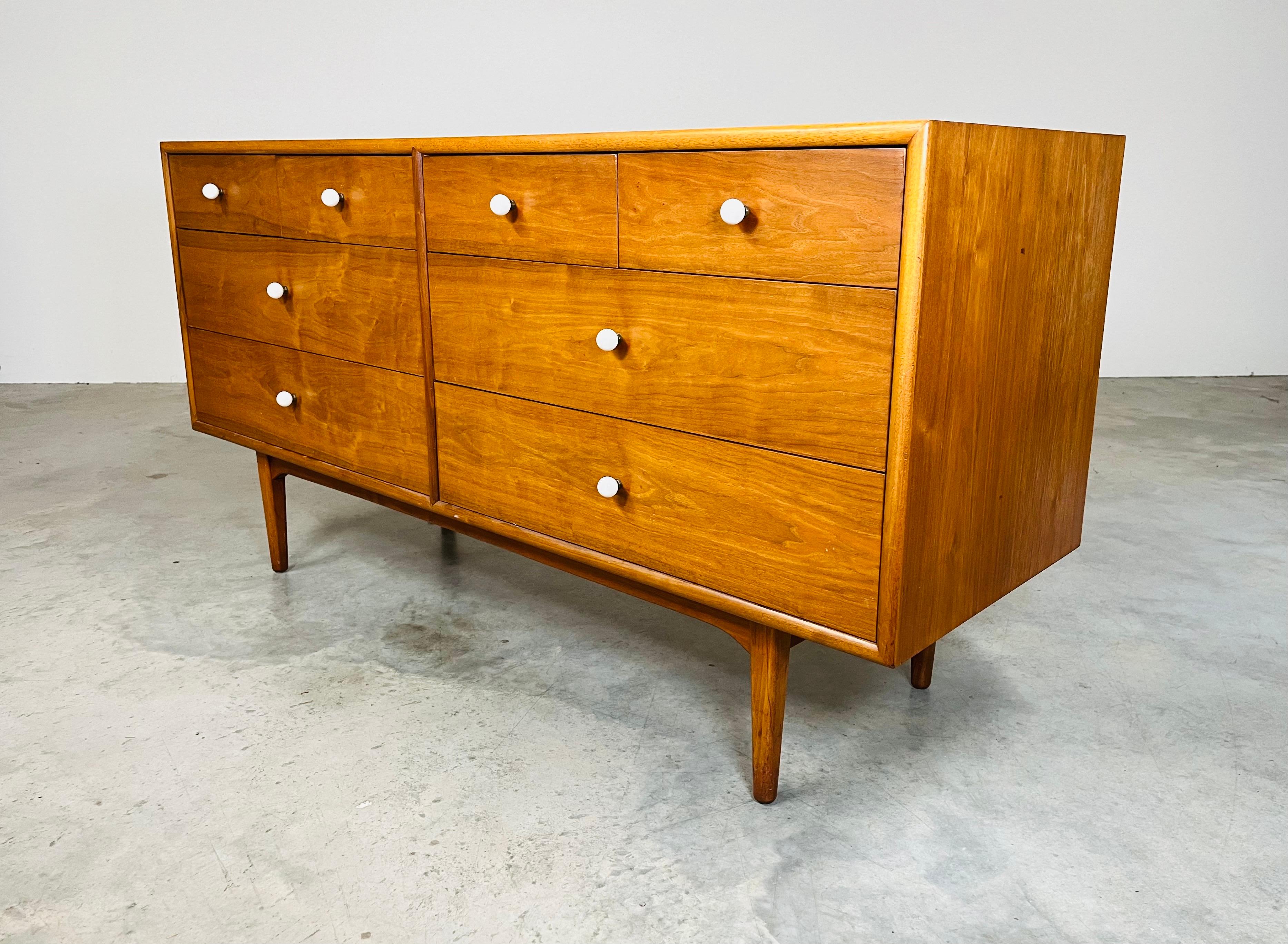 A fabulous 8-drawer dresser or credenza designed by Kipp Stewart having solid walnut construction with porcelain ball drawer pulls that elevate the color contrast to the frontage. 
Manufactured by Drexel for their Heritage series circa 1965. 
In