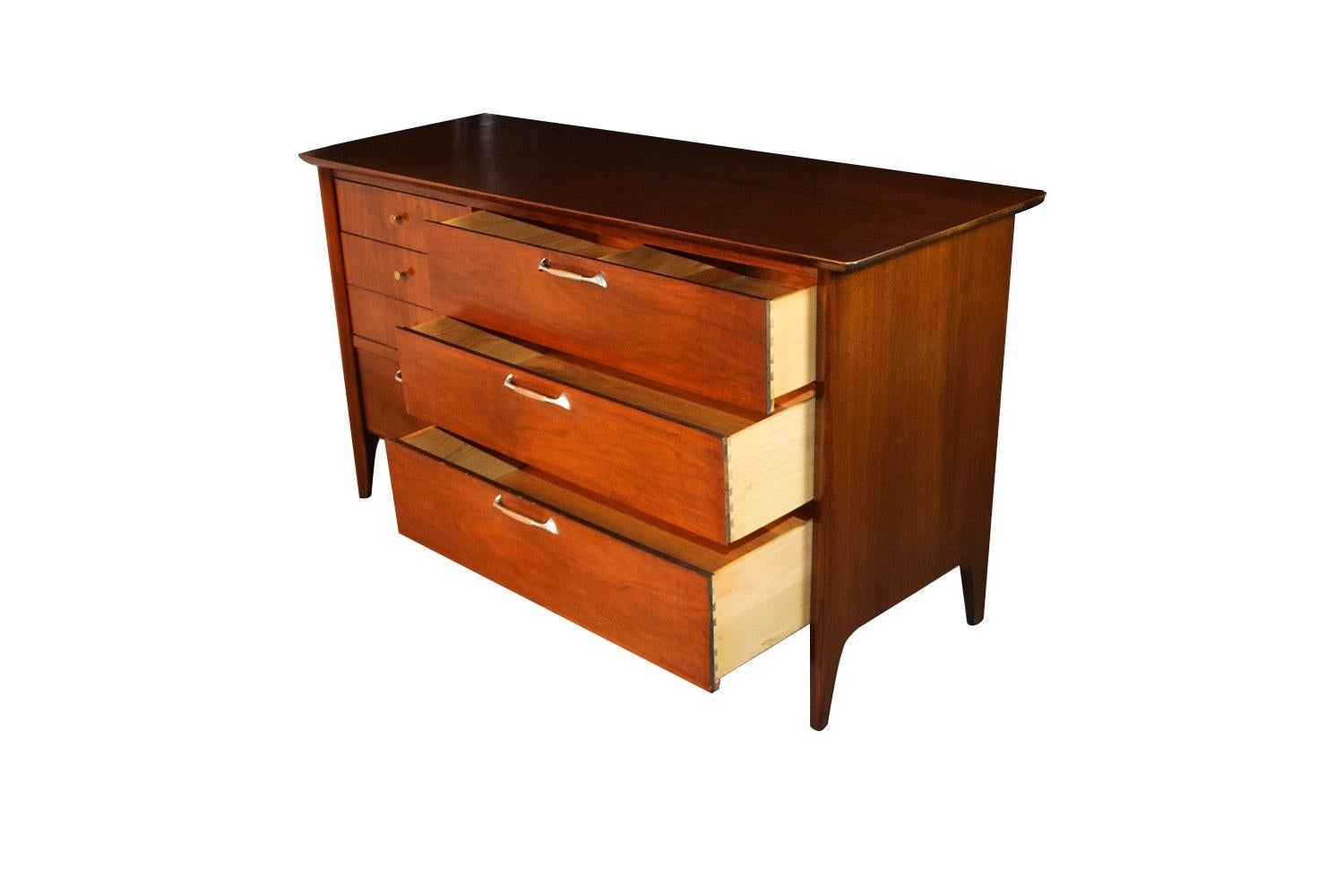 A gorgeous, walnut, midcentury, dresser in nearly pristine condition. Minimalist Danish modern inspired profile, with exceptional construction and style. Features six dovetailed drawers with brass pulls, and painted metal/steel handles, ample