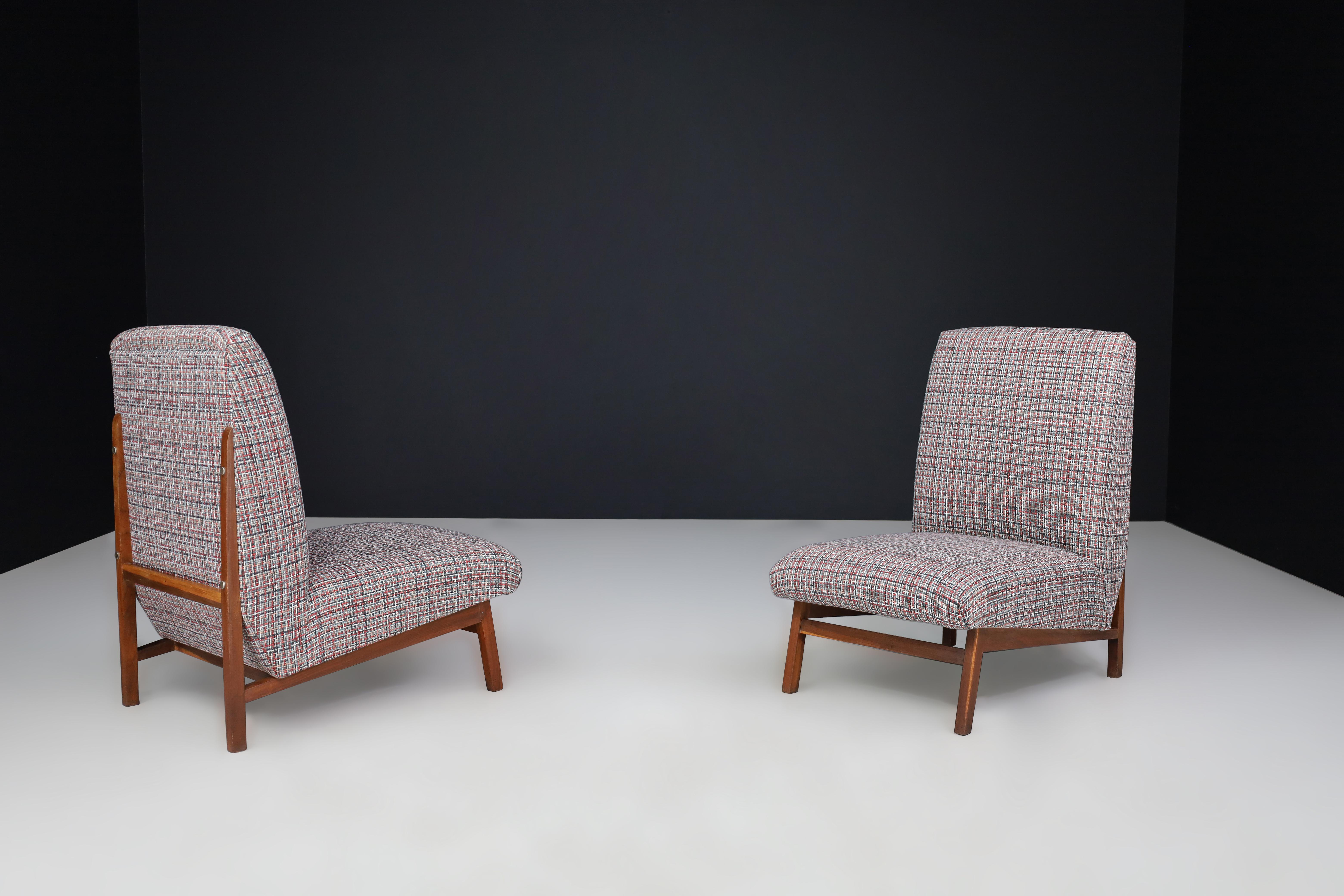 Mid-Century Walnut Easy Chairs, Italy 1960s 

This is a pair of easy chairs that were manufactured in Italy during the 1960s. They showcase a walnut frame and exemplify the Mid-Century Modern style of the era. The chairs have been professionally
