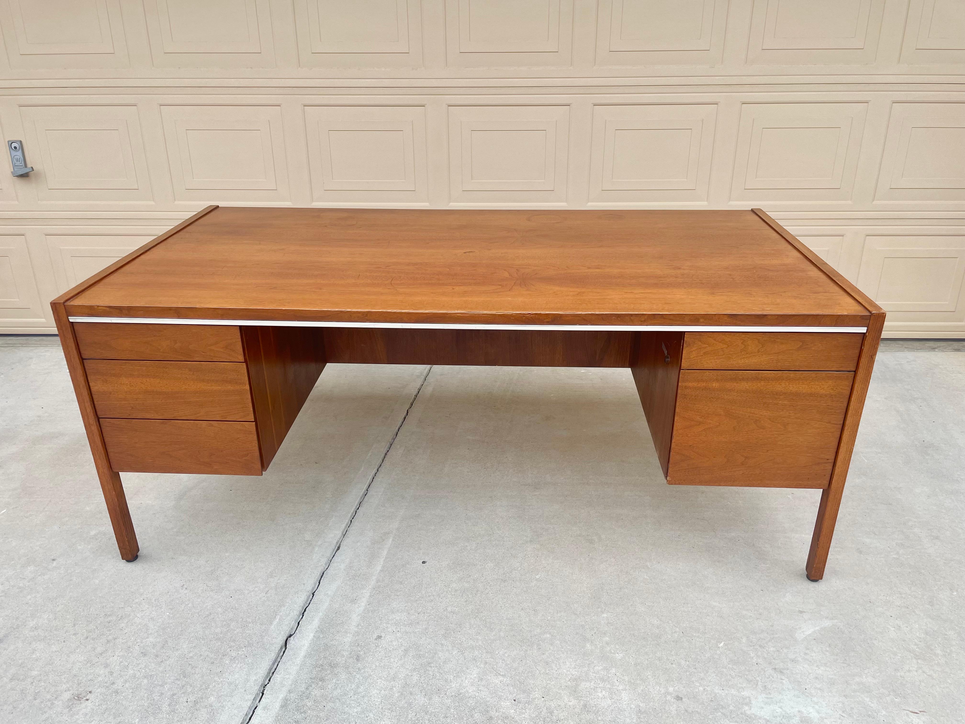 Mid century walnut executive desk designed Borg Warner for Kimball in the United States, circa 1960s. This stunning desk features a strong solid walnut frame that gives an excellent color tone and a beautiful grain pattern. The desk consists of four