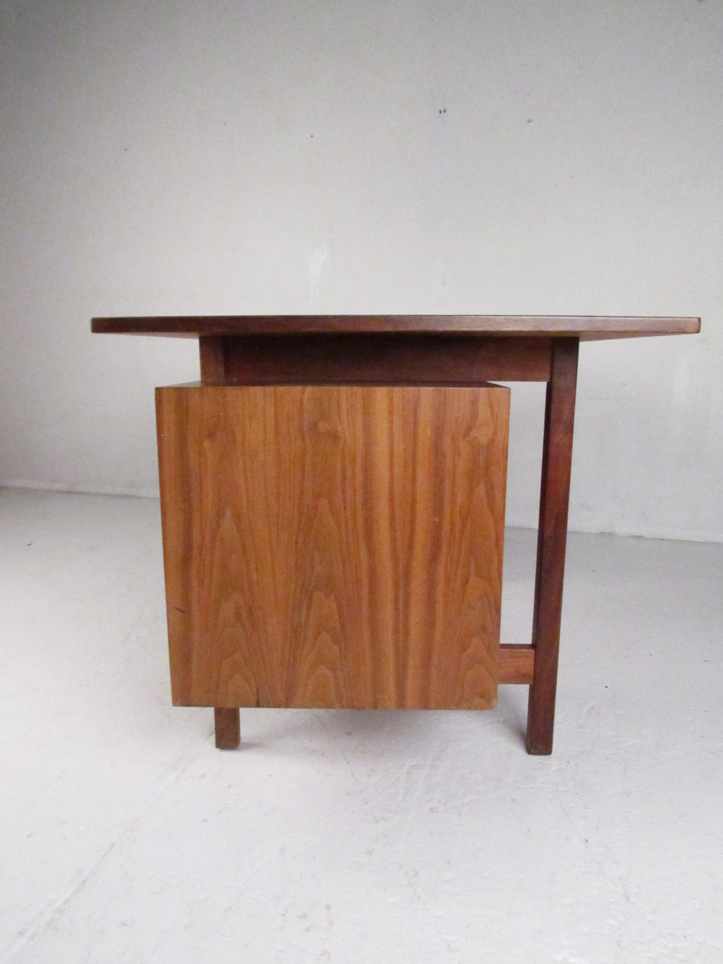 A beautiful vintage modern desk with a floating tabletop and a double pedestal base. The unique design boasts six hefty drawers ensuring plenty of room for storage. A well-made midcentury case piece with a finished back, conical drawer pulls, and a