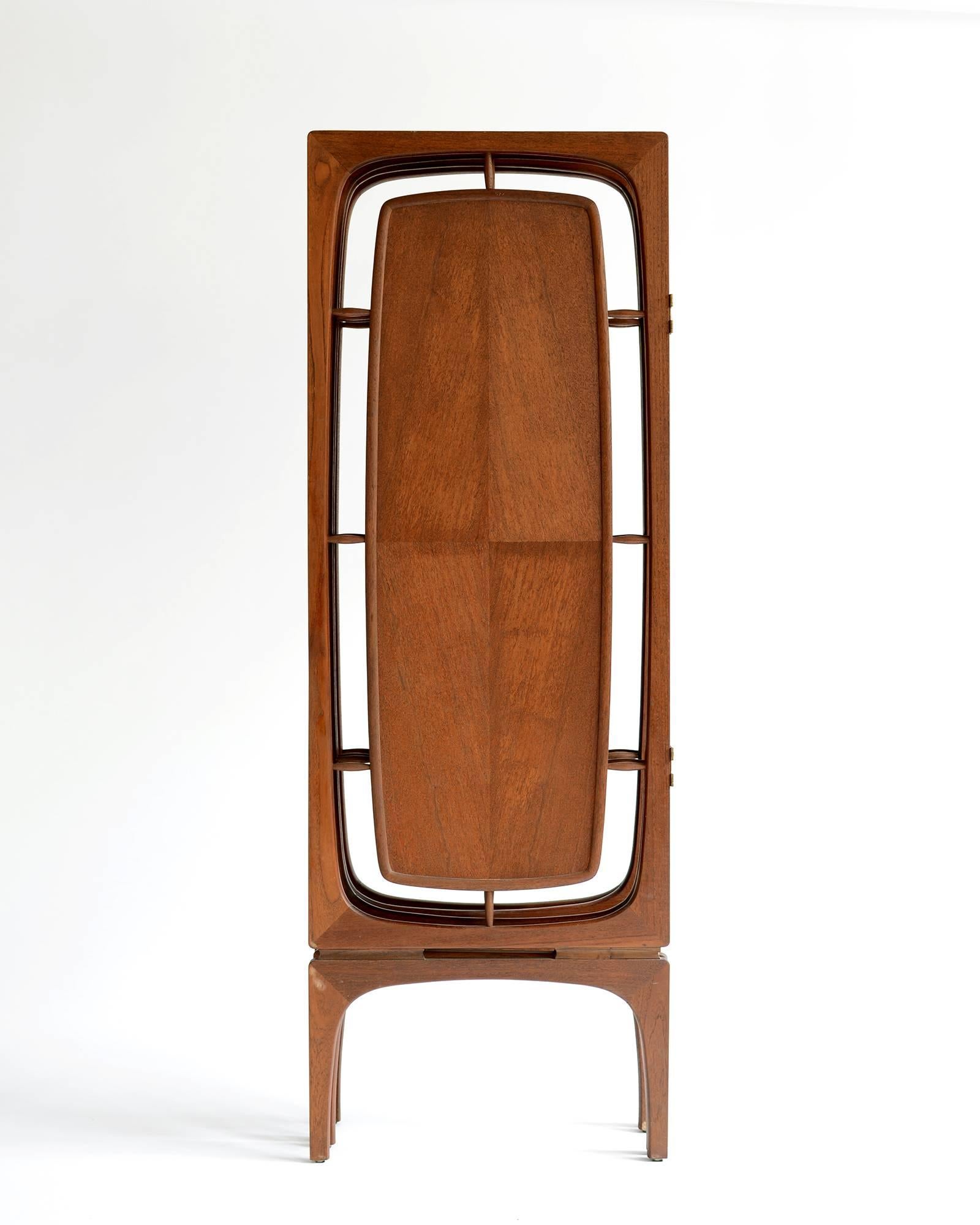 Great sculptural form with four panels elevated on long, elegant legs. Solid walnut frames with floating centre panels of diamond matched veneers. Original brass, double action hinges allow panels to fold in two directions. Original hand rubbed,
