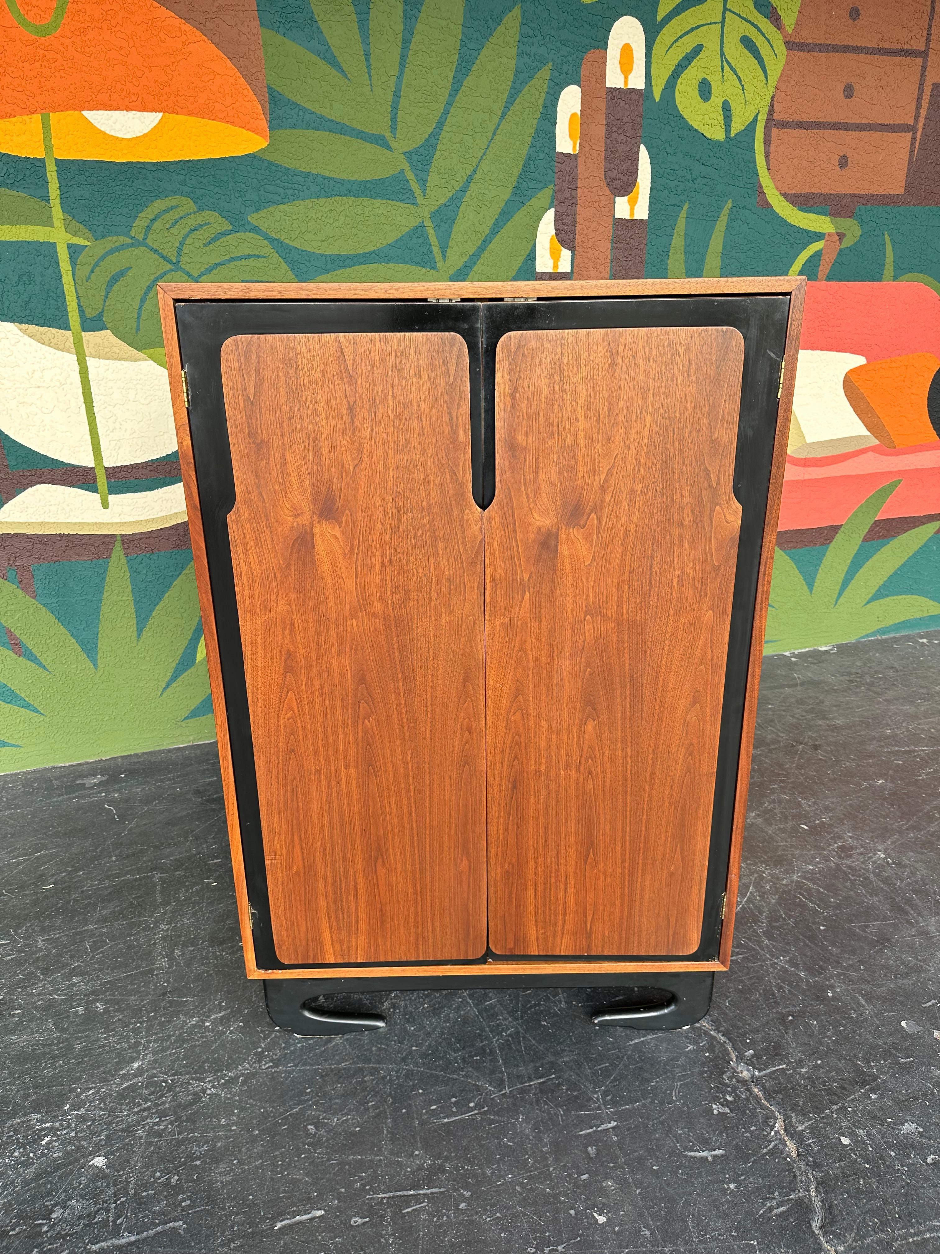 Comò da camera da uomo in Wood del 1970 con finiture nere e insolite gambe curve in legno ebanizzato. Le ante si aprono su 8 cassetti per un ampio spazio di archiviazione. Dimensioni: 36ʺW × 20,5ʺD × 54,5ʺH

In buone ma non perfette condizioni, si