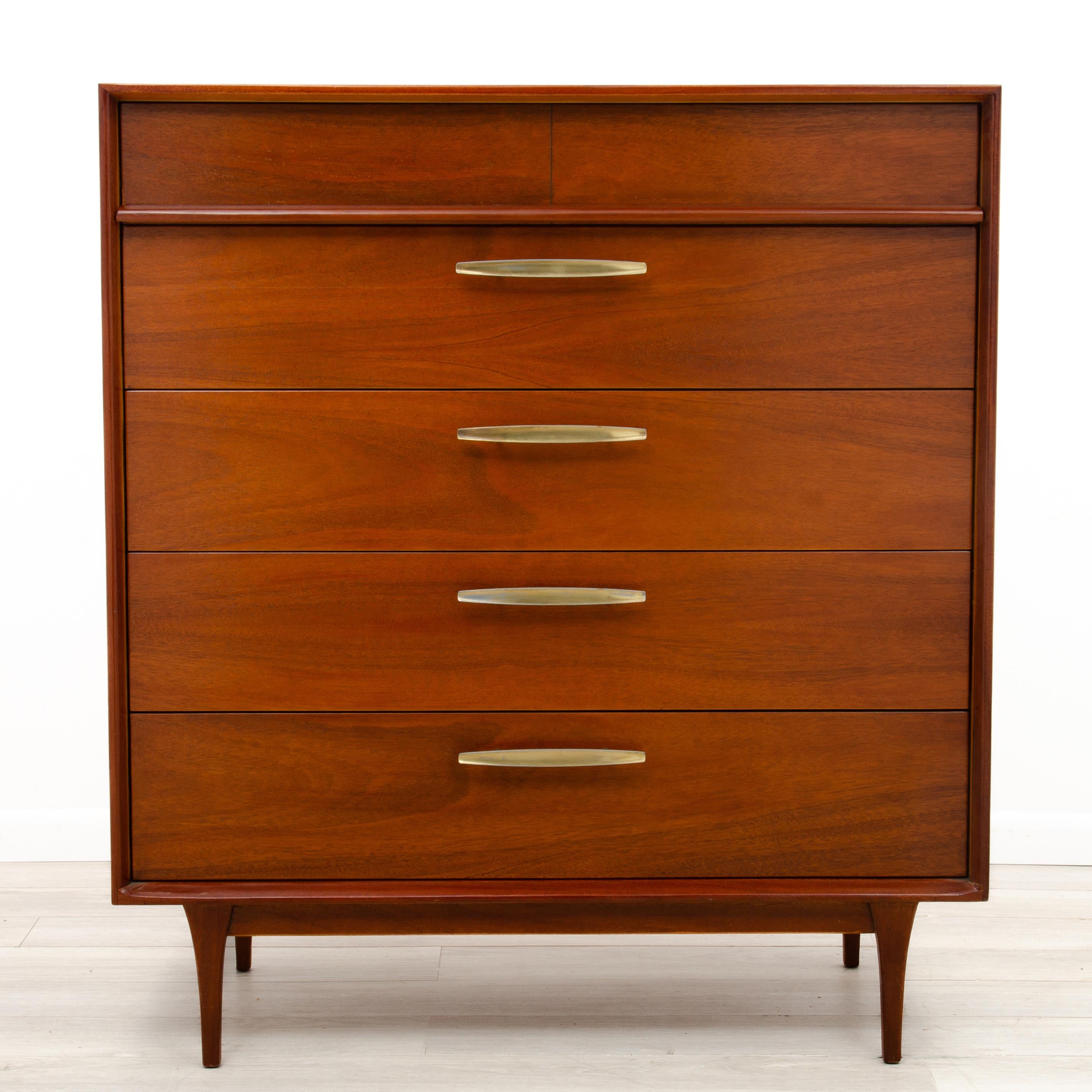 A Mid Century walnut highboy dresser, solid and well made with attention to details. Book matched drawers, one piece veneer tops and sides, quality secondary woods and a nicely finished back. Although we cannot attribute this to a maker, we are
