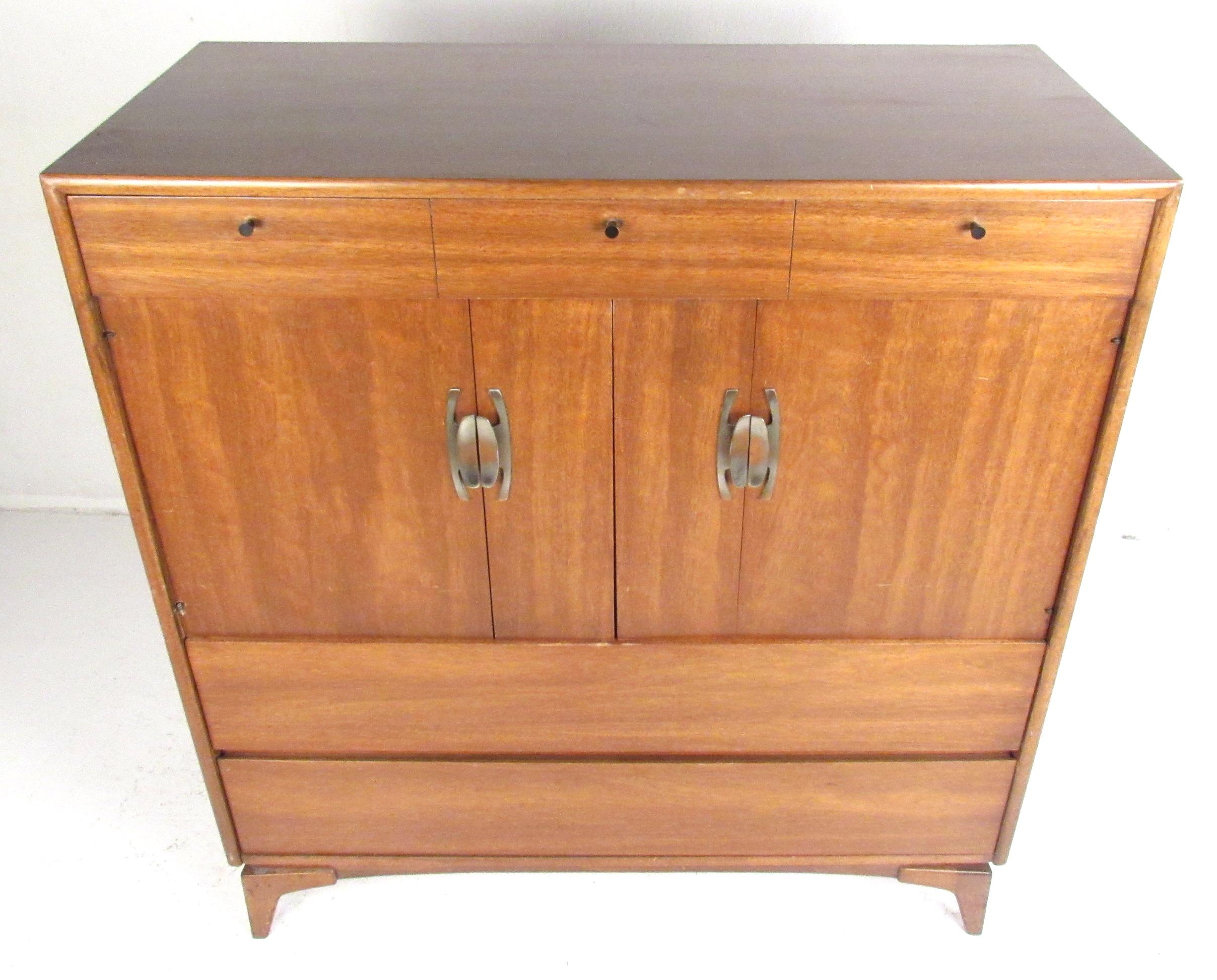 Great midcentury walnut highboy with three large storage drawers and four trays concealed behind a pair of bi-fold doors. Please confirm item location (NY or NJ) with dealer.