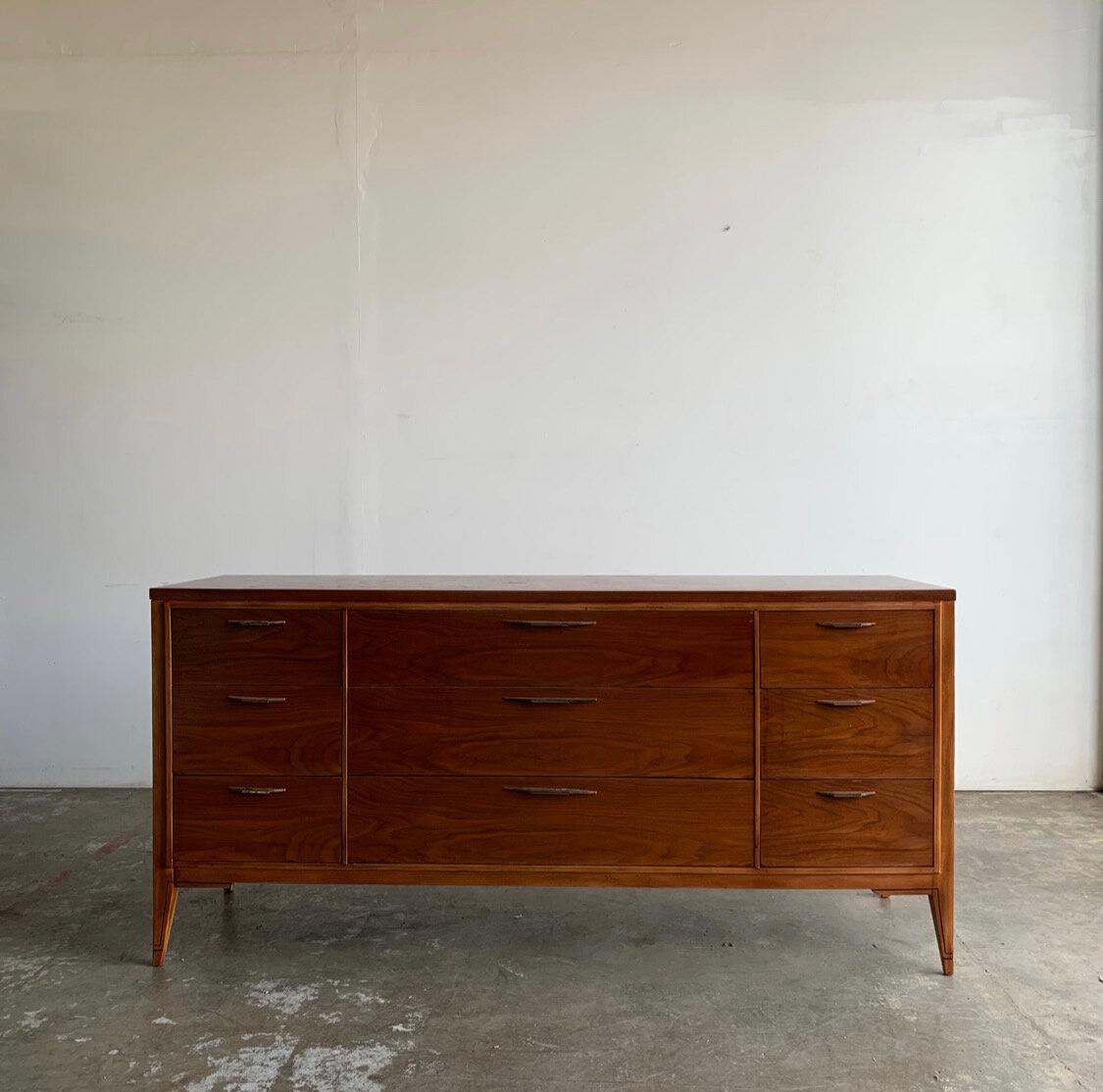 Mid century dresser by Kent Coffey. Nine drawers full of storage provides ample storage space. Dresser sits on tapered legs and handles are original. Made of walnut wood for Kent Coffey’s Tempo collection as marked.