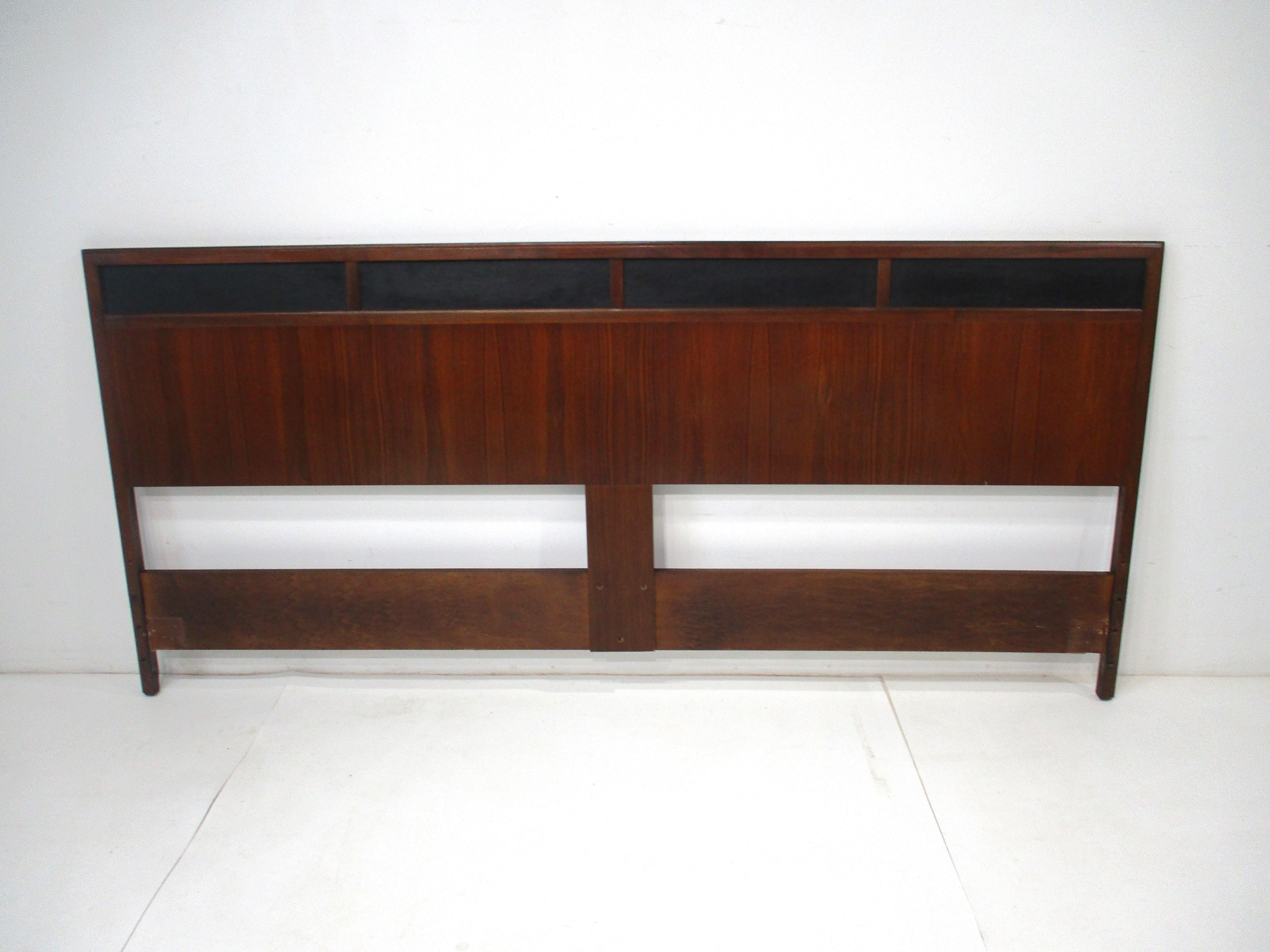 A Mid Century walnut King sized headboard designed by Jack Cartwright for the Founders Furniture company . Satin black leatherette inset detail to the top edge of the headboard gives the piece a tight and tailored look fitting in with many interiors