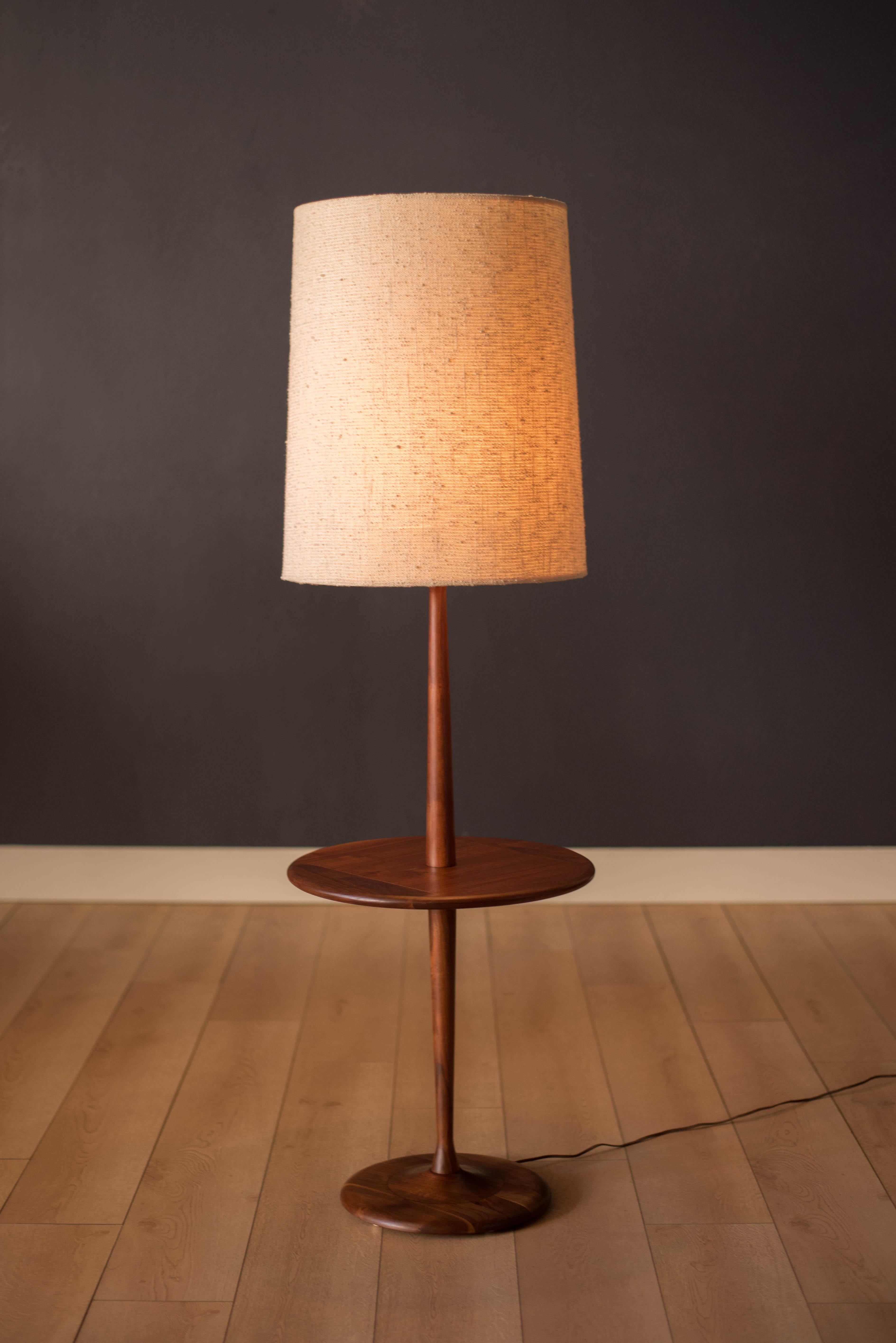 Vintage floor lamp with attached round side table by Laurel Lamp Co. circa 1960s. This piece is made of solid walnut and functions with a three-way switch. Drum shade is not included. 

End table height 20.75
