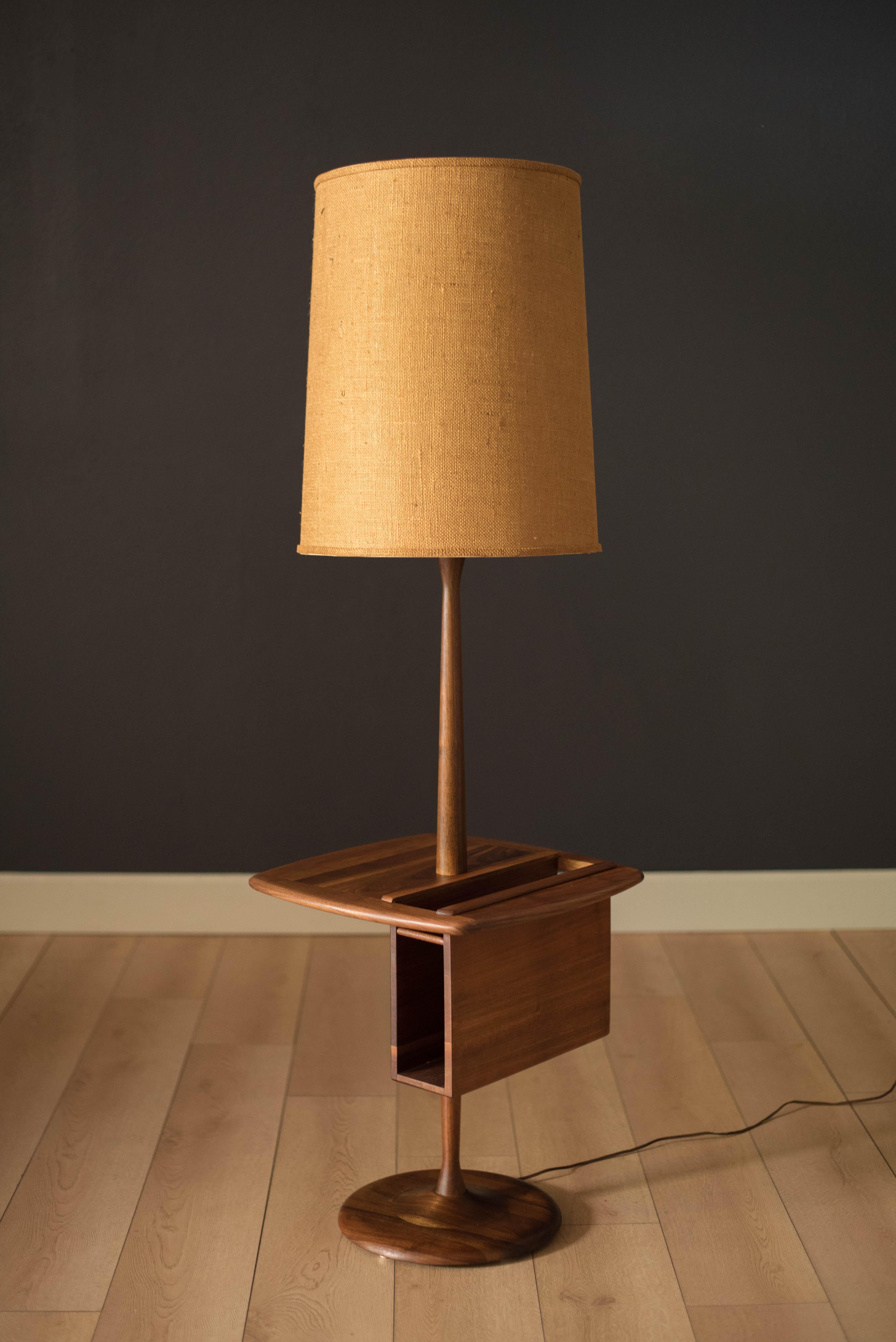 Vintage floor lamp with attached side table in walnut by Laurel Lamp Co. This versatile piece includes a magazine or book holder and burlap drum shade. 

 