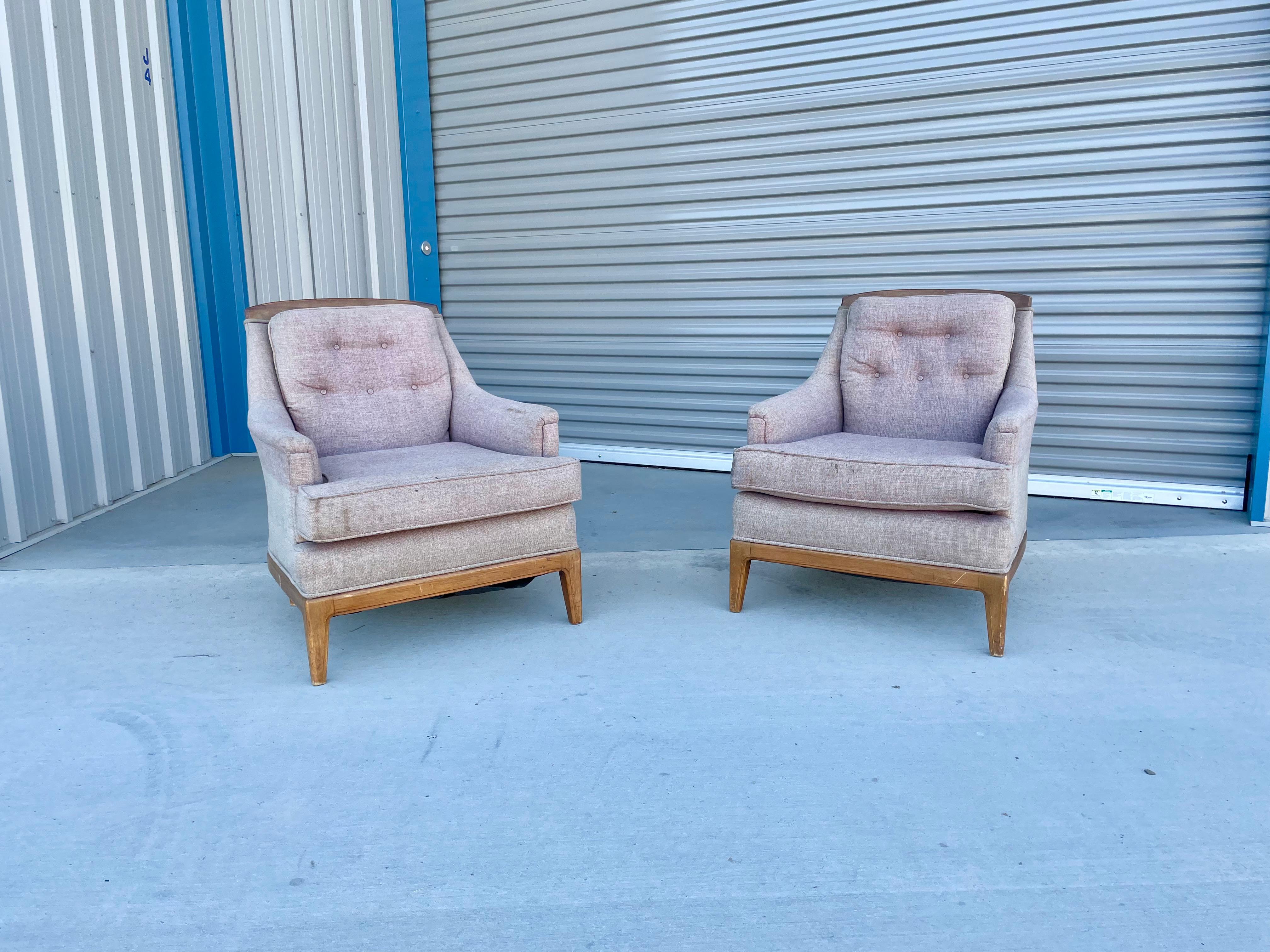 Vintage walnut lounge chairs were designed and manufactured in the united states circa 1960s. This pair of chairs features its original upholstery that needs to be reupholstered, but perfect opportunity to create your ideal design that fits your