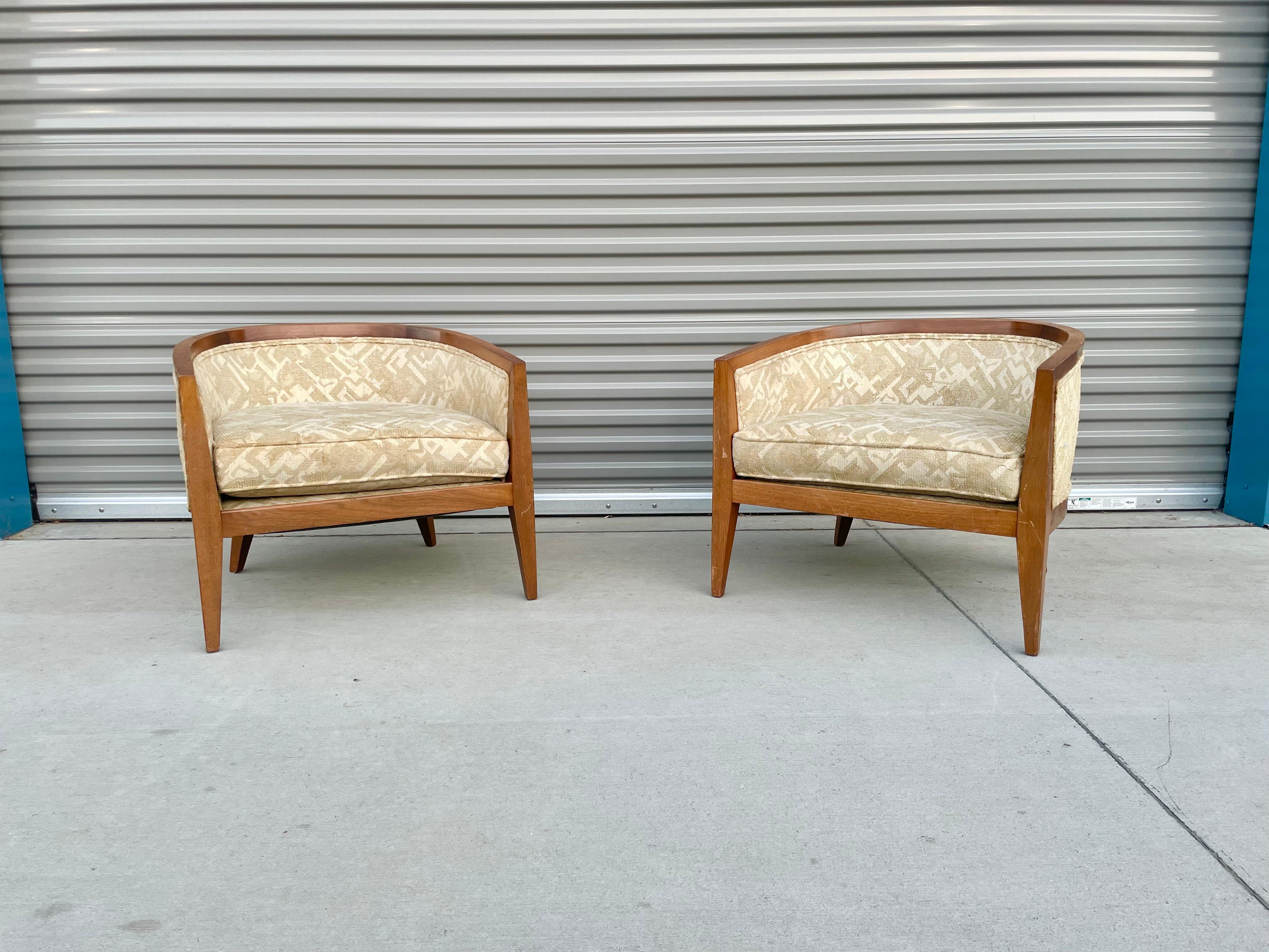 Mid-century walnut lounge chairs were designed and manufactured in the united states circa 1960s. These chairs feature a walnut frame with a wide curved backrest, offering solid support with comfort and ready to be used for years to come.