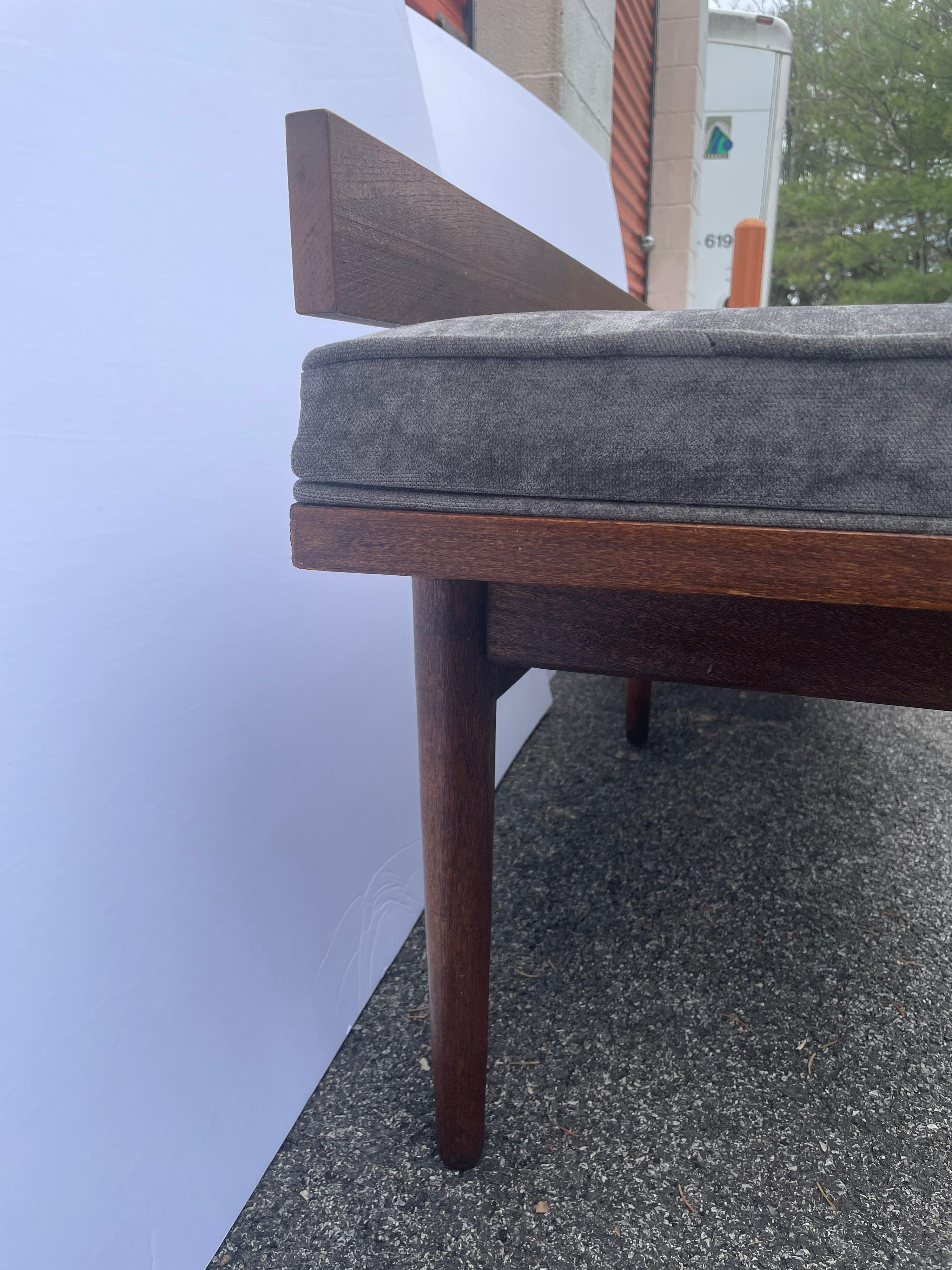 Mid century walnut low back bench. Covered in charcoal velvet. Can be used with or without low walnut back, bench is finished on all four sides. Frame in good overall condition, with some wear to finish from age and use.