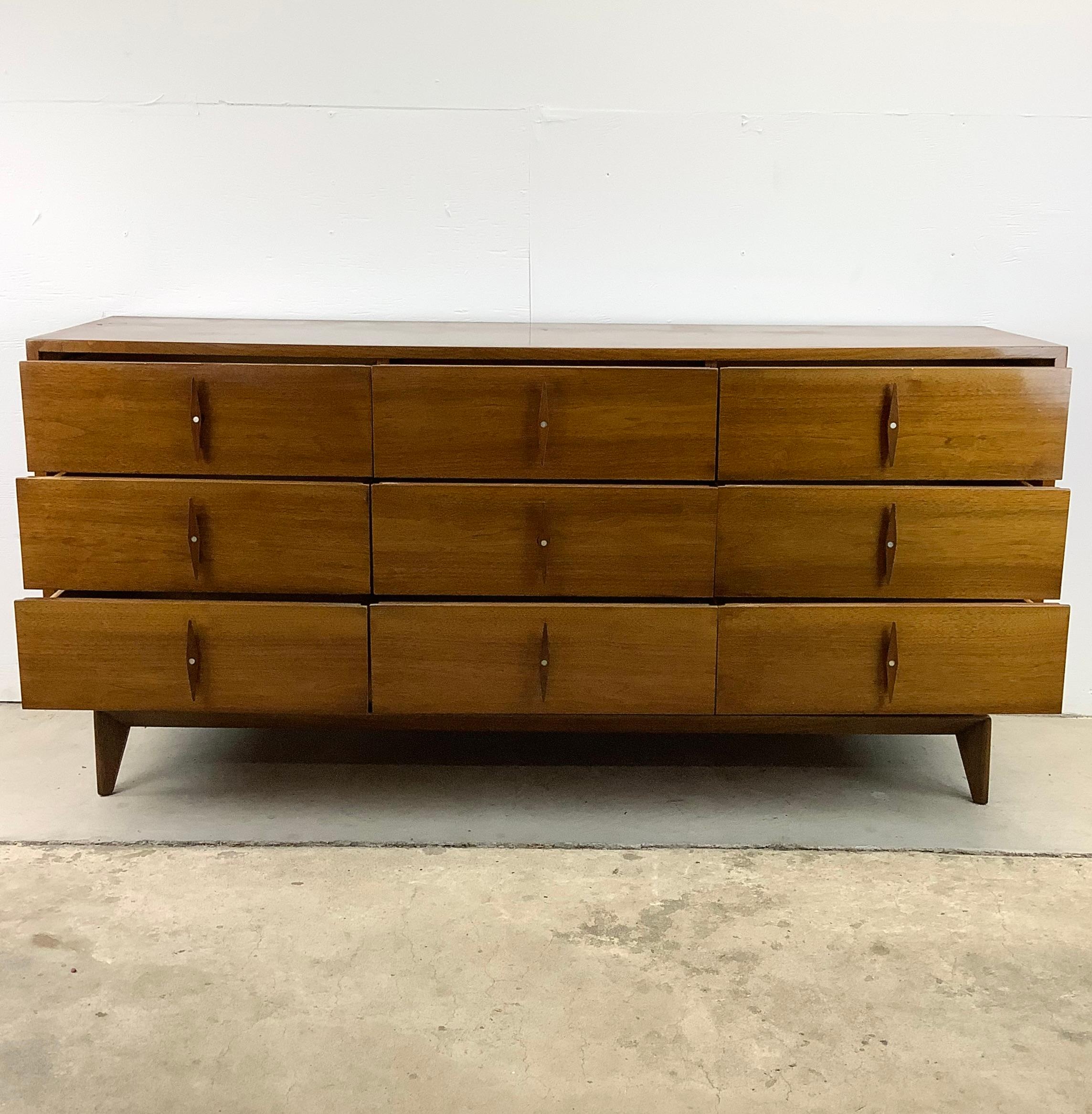 This Vintage American of Martinsville Lowboy dresser captures the essence of mid-century style while offering practical functionality for your home decor needs.

Manufactured with meticulous attention to detail, this nine drawer walnut dresser