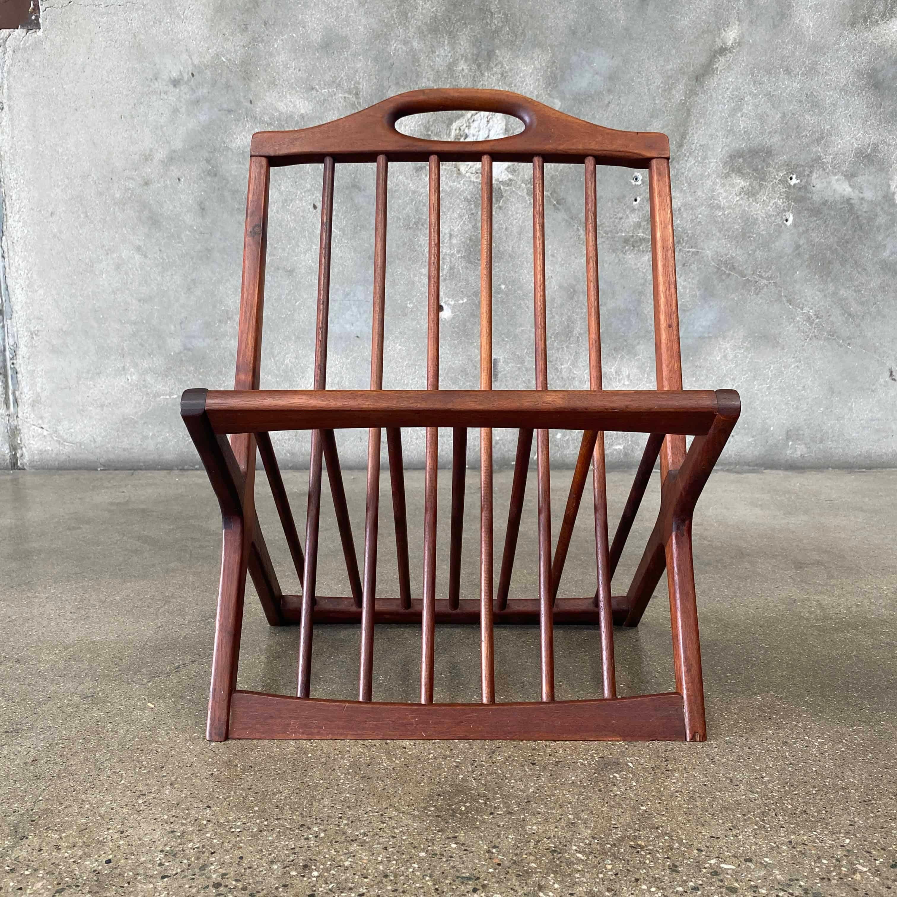 Porte-revues en noyer de style moderne du milieu du siècle, réalisé par Arthur Umanoff pour Washington Woodcraft. Construite avec des fuseaux en noyer, la crémaillère est dotée d'une poignée découpée. 