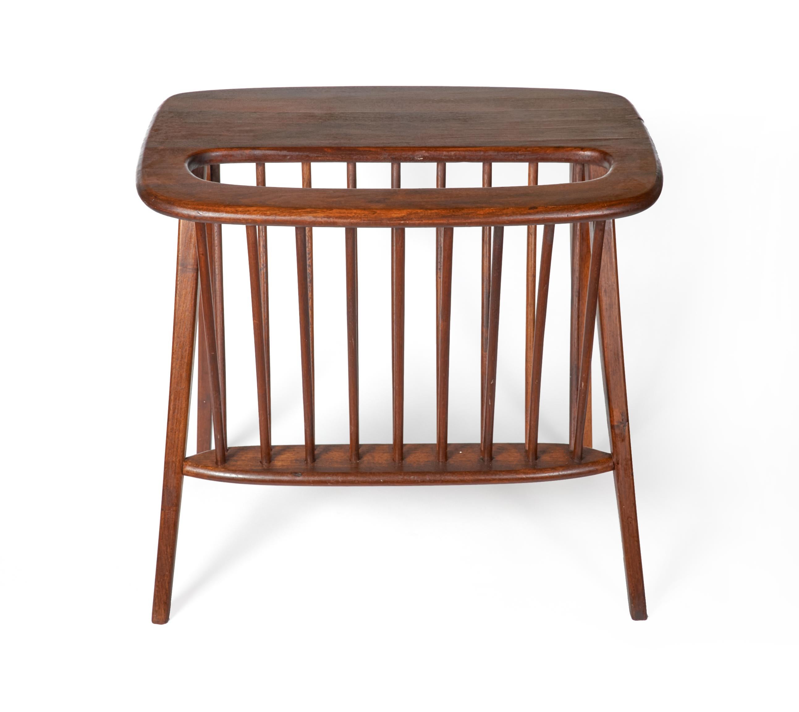 Stylish Mid-Century Modern walnut end table with a built in magazine rack bu designer Arthur Umanoff. Table is in great condition with minimal signs of use.
Umanoff was a graduate of Pratt University in the early 1950s. Around that same time, he