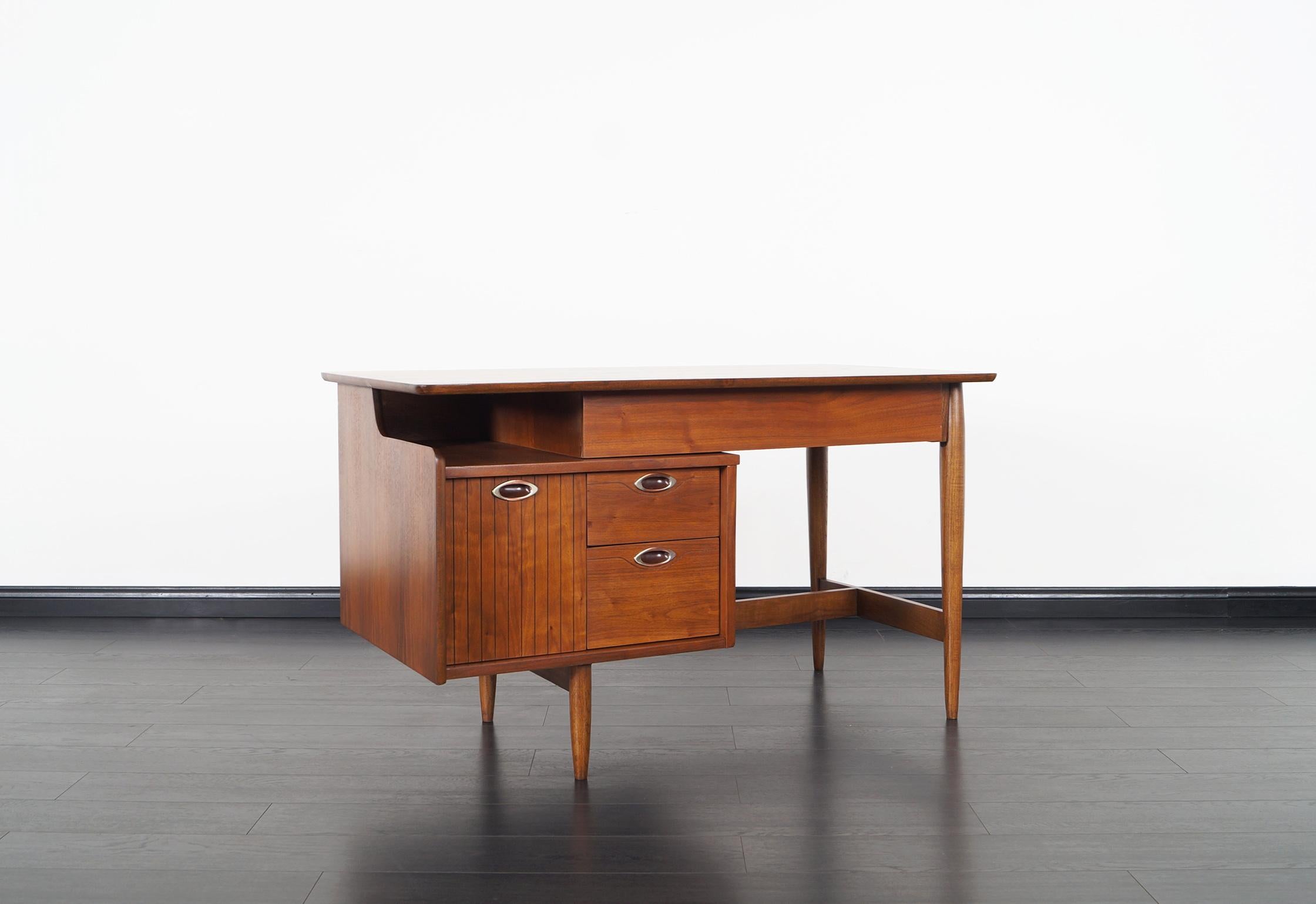 Mid-Century Modern walnut desk was manufactured by Hooker Furniture, as part of the 