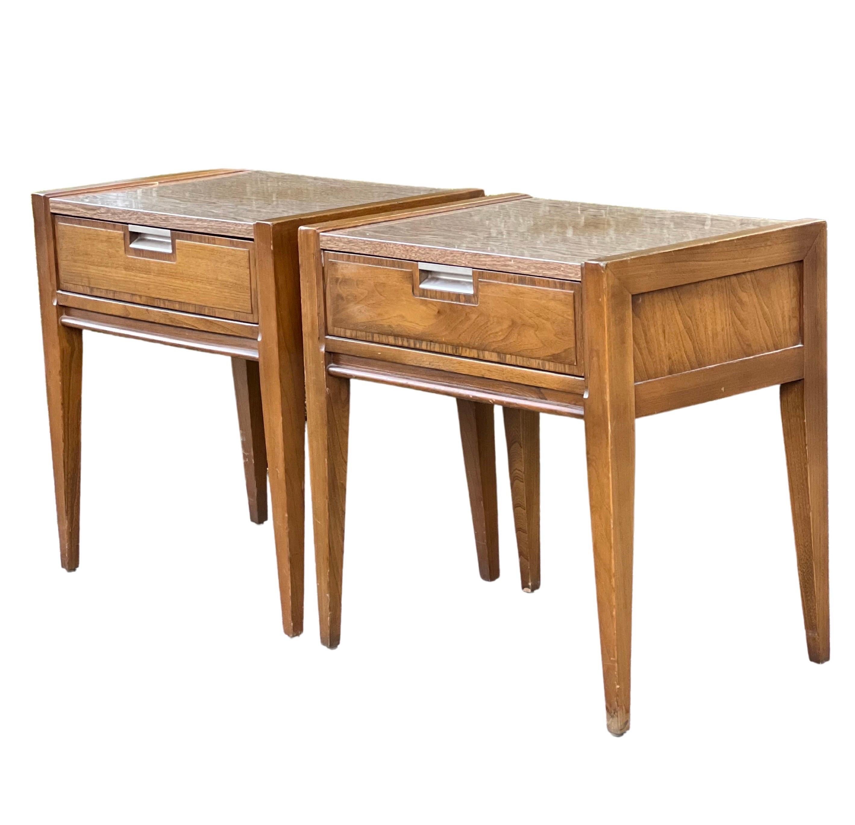 Great pair of mid century walnut nightstands by Basic Witz. 

These lovely stands feature one dovetail drawer with cross-band detail and an inset brushed aluminum pull. The tops have a protective laminate creating an attractive, lightly two-toned