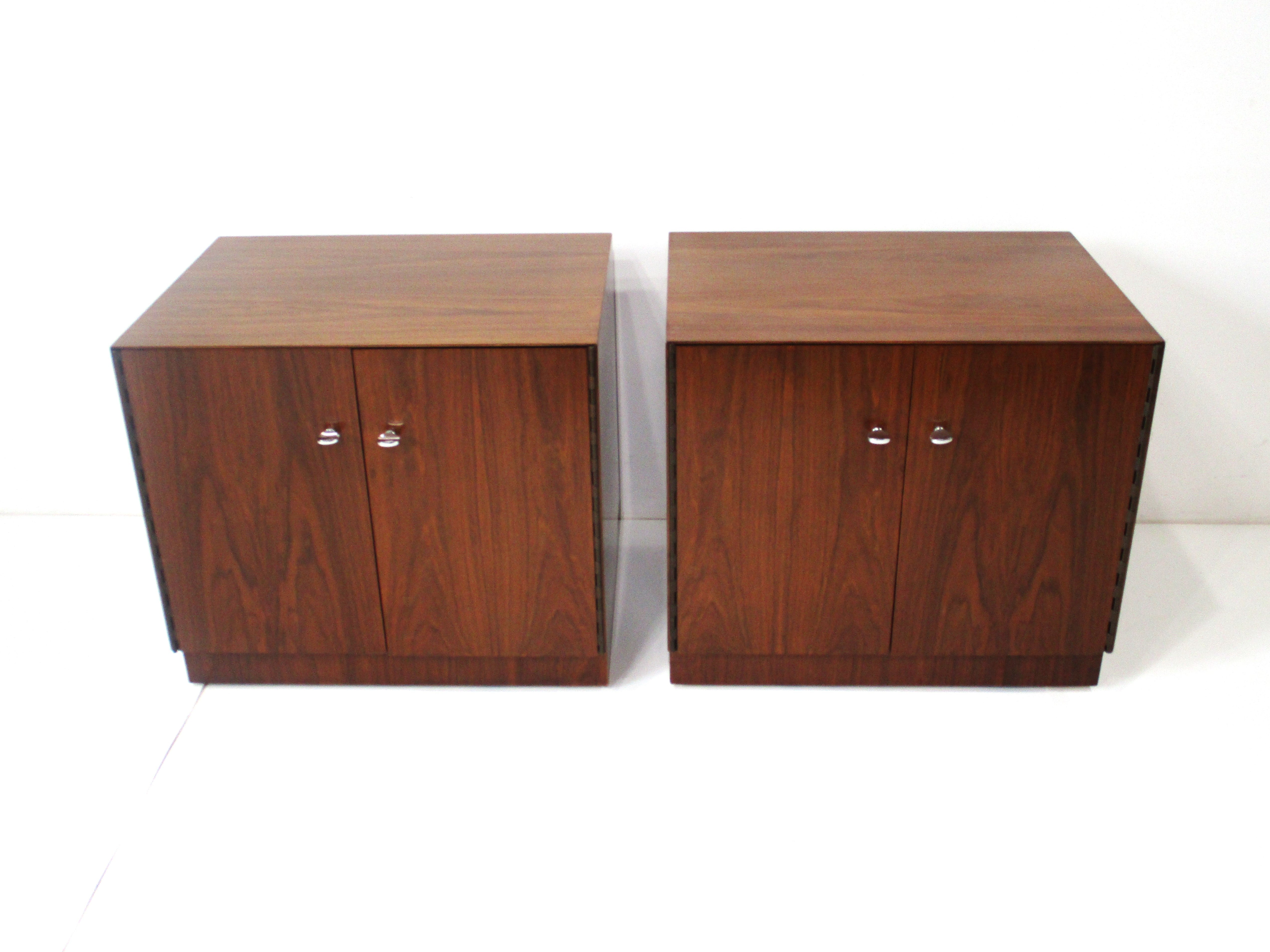 A pair of very well crafted walnut Mid Century nightstands with wonderful rich graining in the manner of Milo Baughman and Harvey Probber . Having double doors with sturdy piano styled hinges , heavy chromed metal pulls and an adjustable shelve