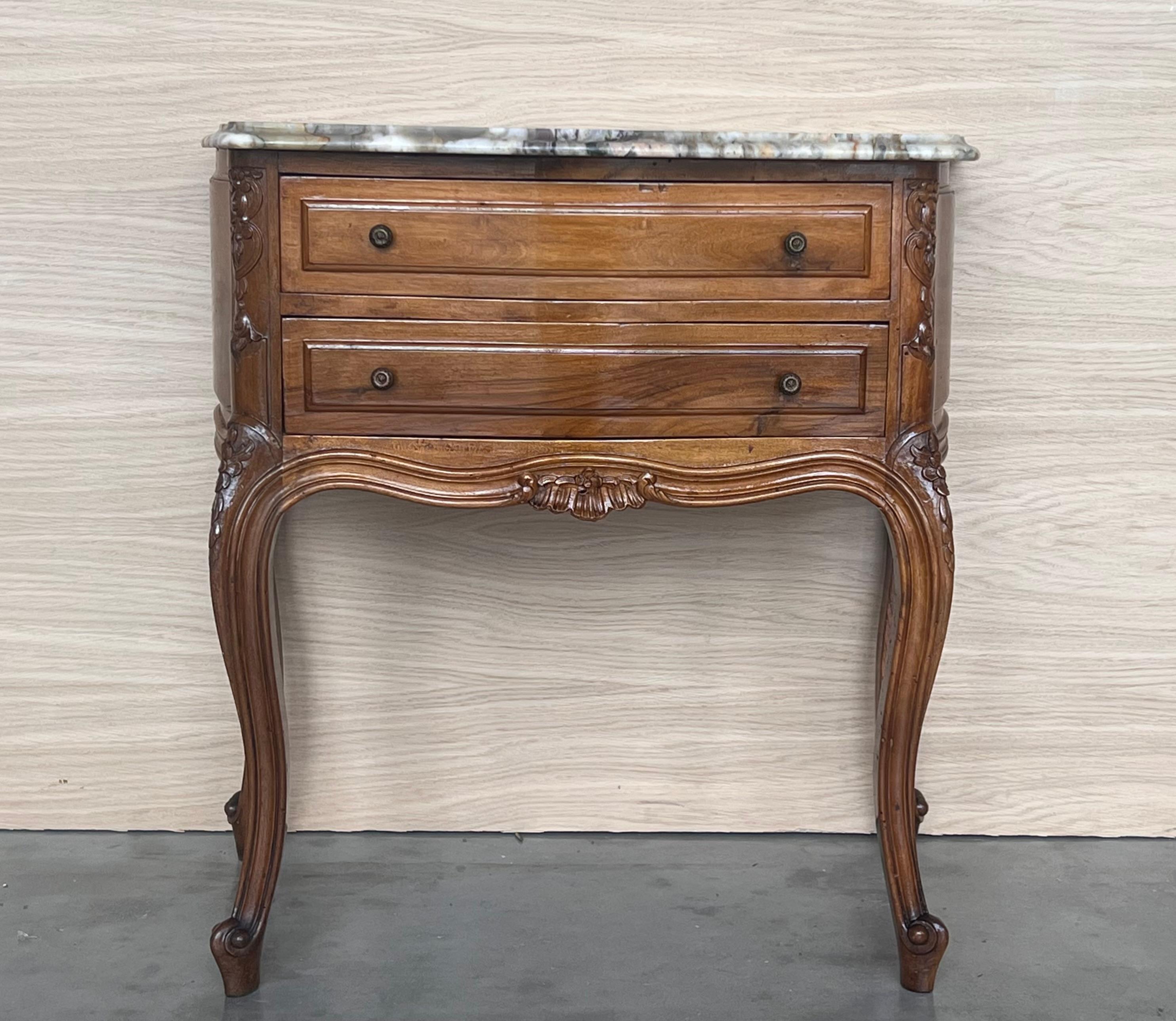 We are delighted to introduce this pair of French walnut nightstands.
The front drawers have this beautiful burr in the wood, with original handles to open all the drawers and white marble top.
Also, the legs are very well carved and shaped.

We