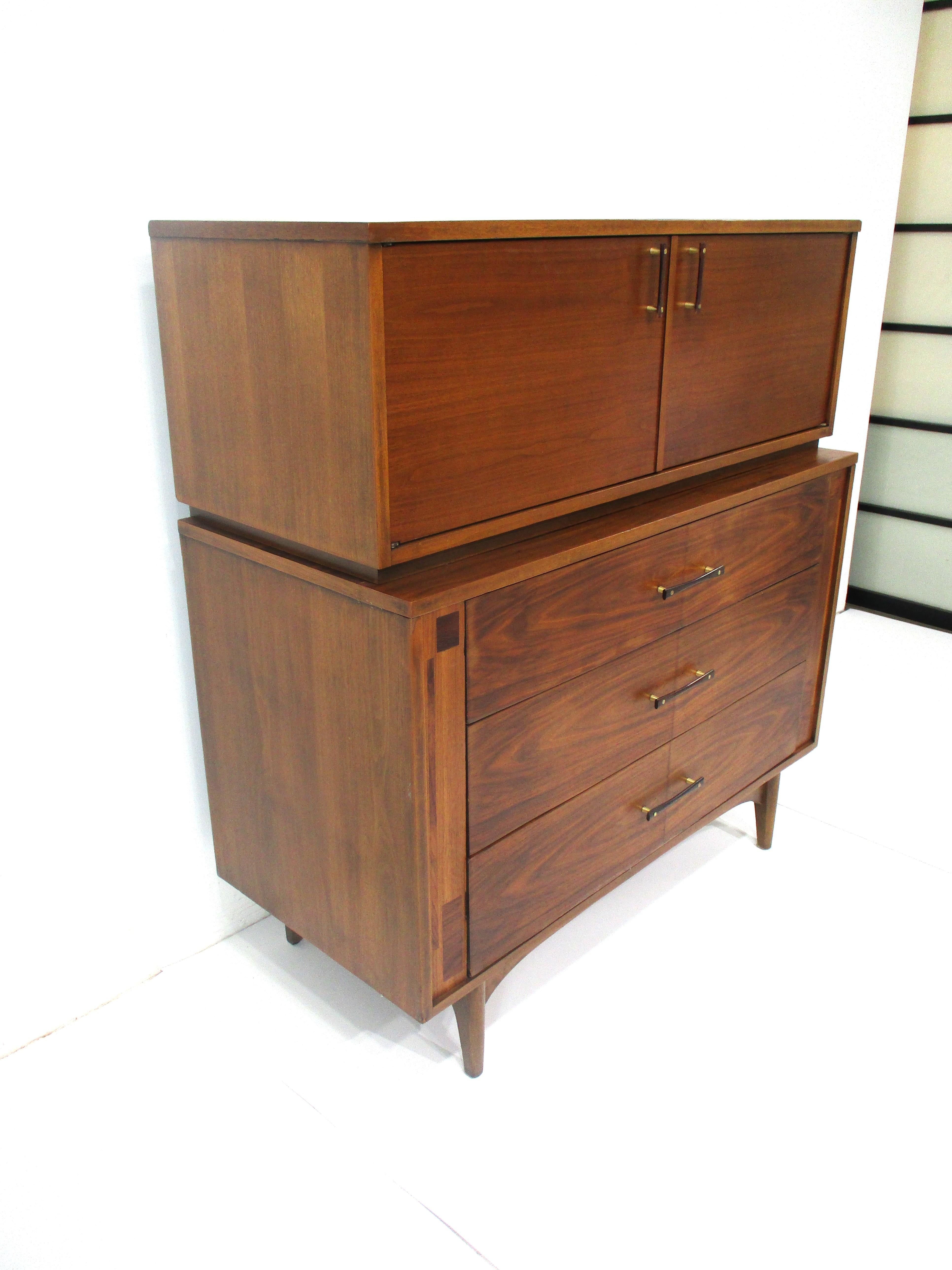 A very well crafted walnut chest on chest highboy dresser with upper doors , two drawers with one having dividers and three storage areas which are very functional . The lower larger three drawers one having dividers gives you plenty of storage all