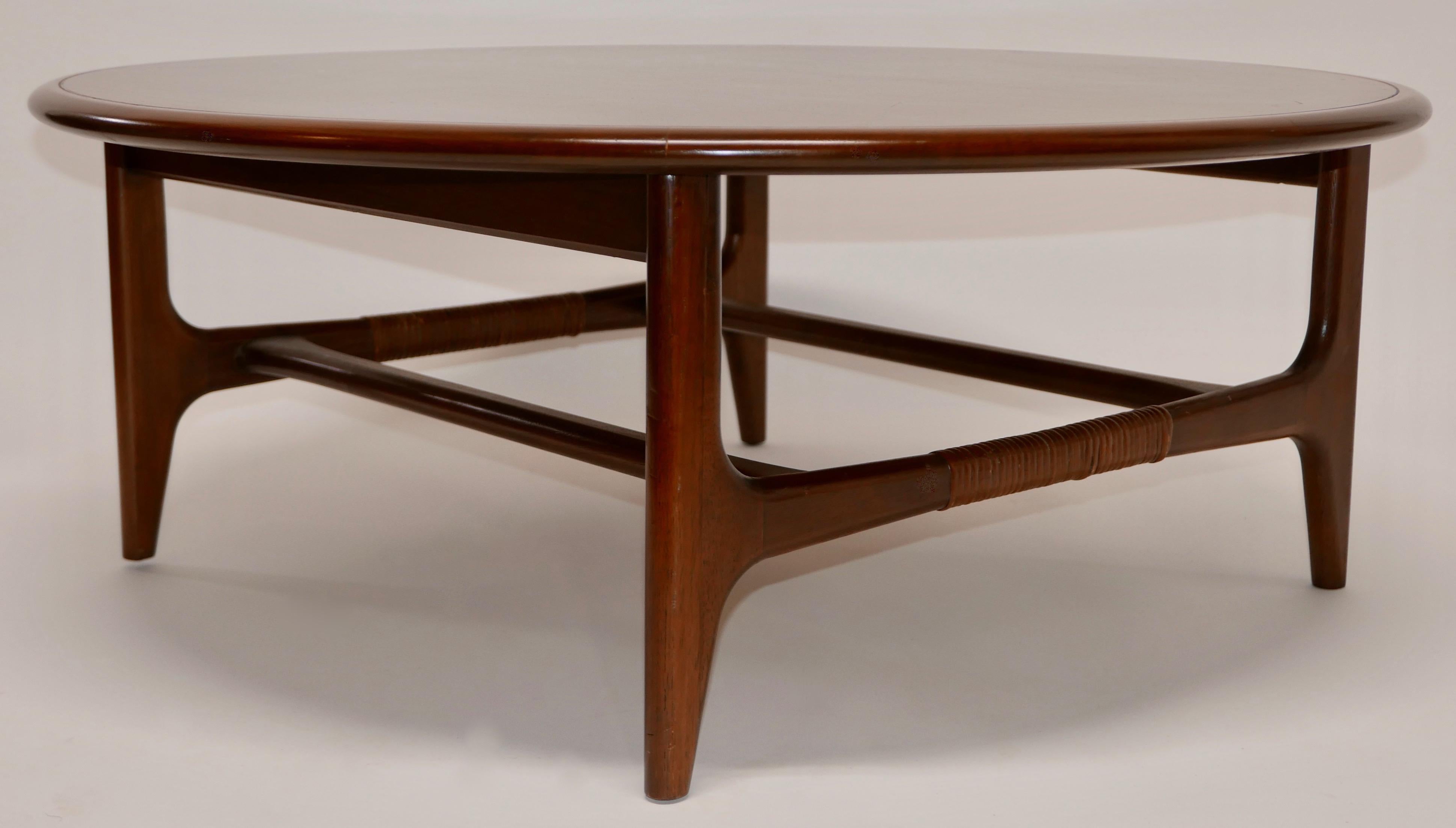 Fantastic Mid-Century Modern, round coffee table by Lane, Altavista, Virginia. This table has a round walnut top with a starburst wood inlay atop a contrasting square walnut base with woven detail.
American, circa 1962.