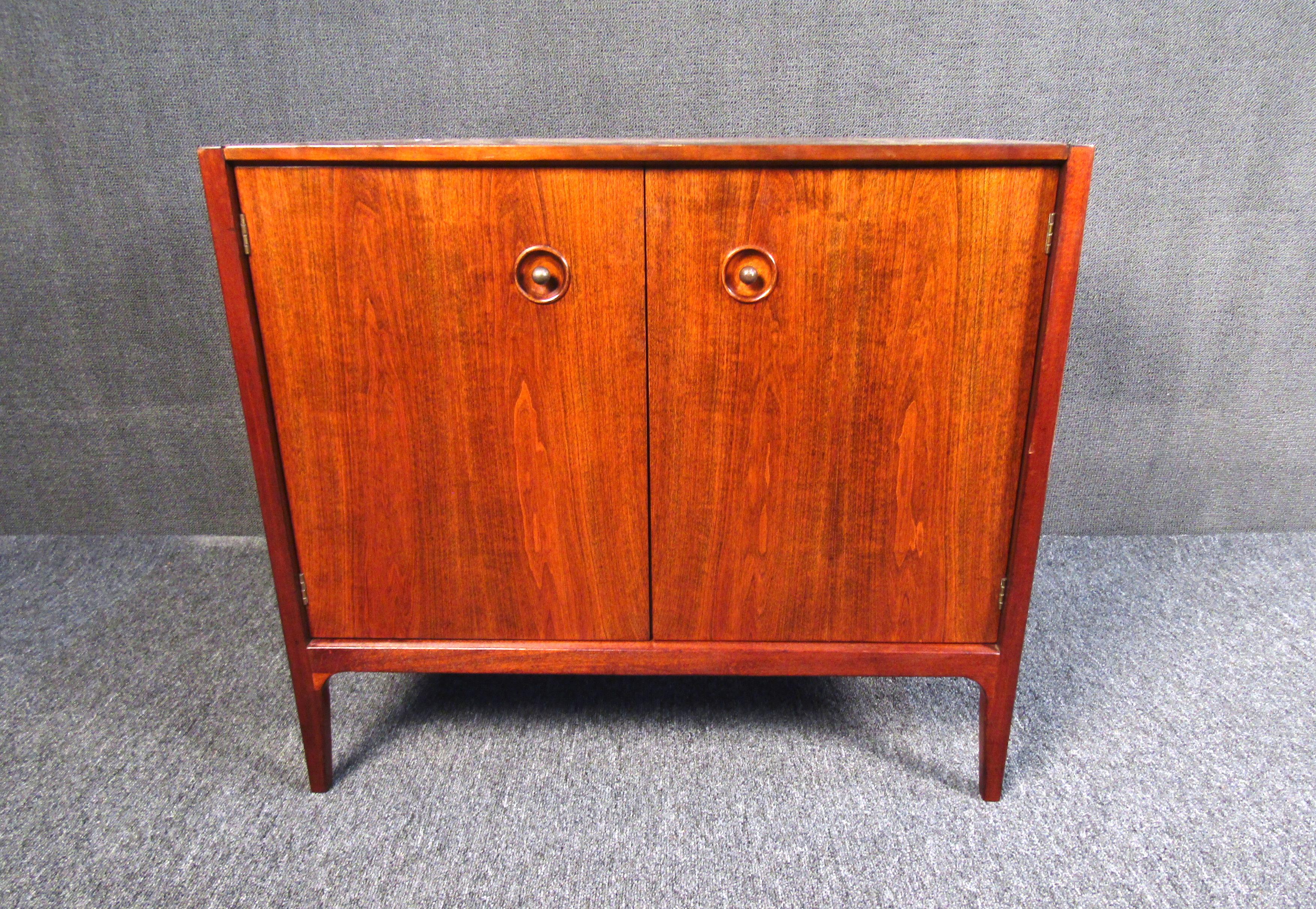 This gorgeous Mid-Century Modern side chest displays a rich walnut woodgrain and a quality design by Drexel. With plenty of storage for its size and compact design, this well-made American side chest is sure to be a great addition to any bedroom,