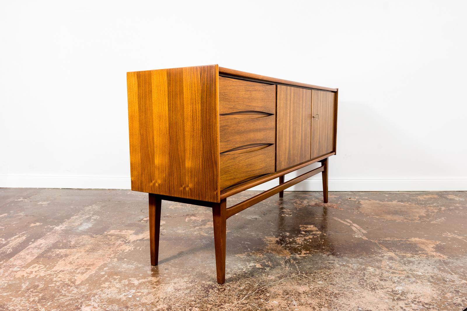 Walnut veneer Mid-Century sideboard from Bydgoskie Furniture Factory, Poland 1960s
This item has 2 doors, 1 long shelf and 3 drawer. ( top is cutlery drawer)
Case raised on solid wooden construction and legs.
Sideboard have been completely restored