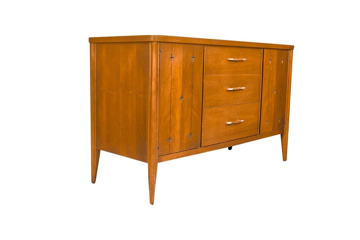 A beautiful, sleek mid-century modern walnut, Credenza/ Sideboard, circa early 1960's from Broyhill Premier’s “Saga” collection. This absolute jewel remains in nearly pristine condition. The lines are clean and elegant.  Features three spacious