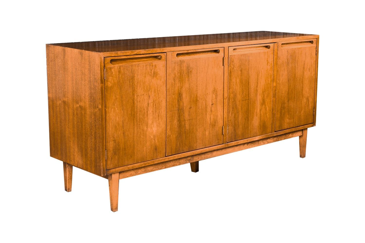 Beautiful, retro Mid-Century Modern detailed proportioned walnut American of Martinsville credenza/sideboard, media console with drawers in good original condition. Features double cabinet doors that open to reveal two bays outfitted with a walnut