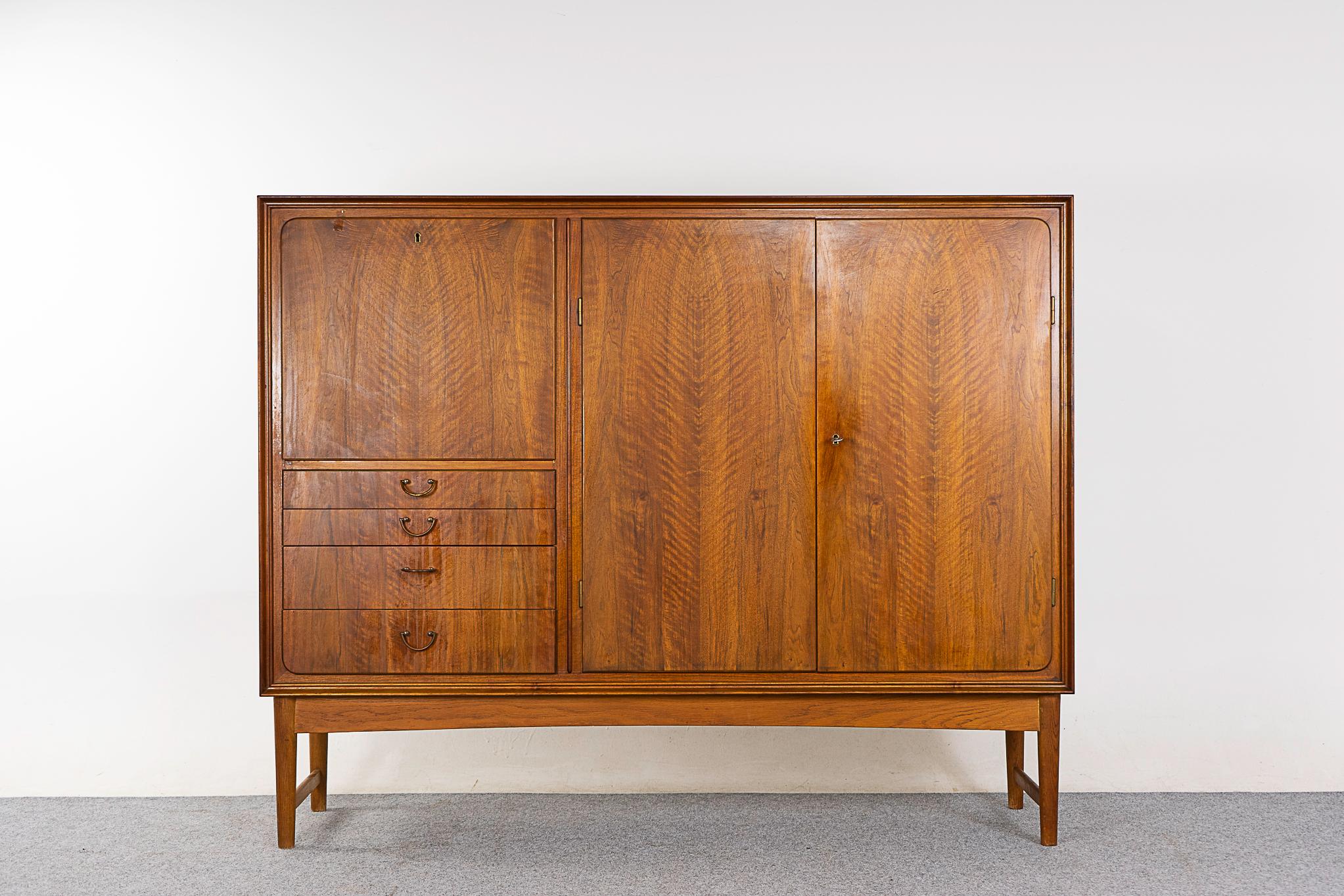 Walnut Danish sideboard, circa 1960's. Stunning simple lined design with exceptional book-matched veneer. Drop down door reveals a charming bar with a curved adjustable shelf for tall bottles. Interior shelving behind the large double doors is