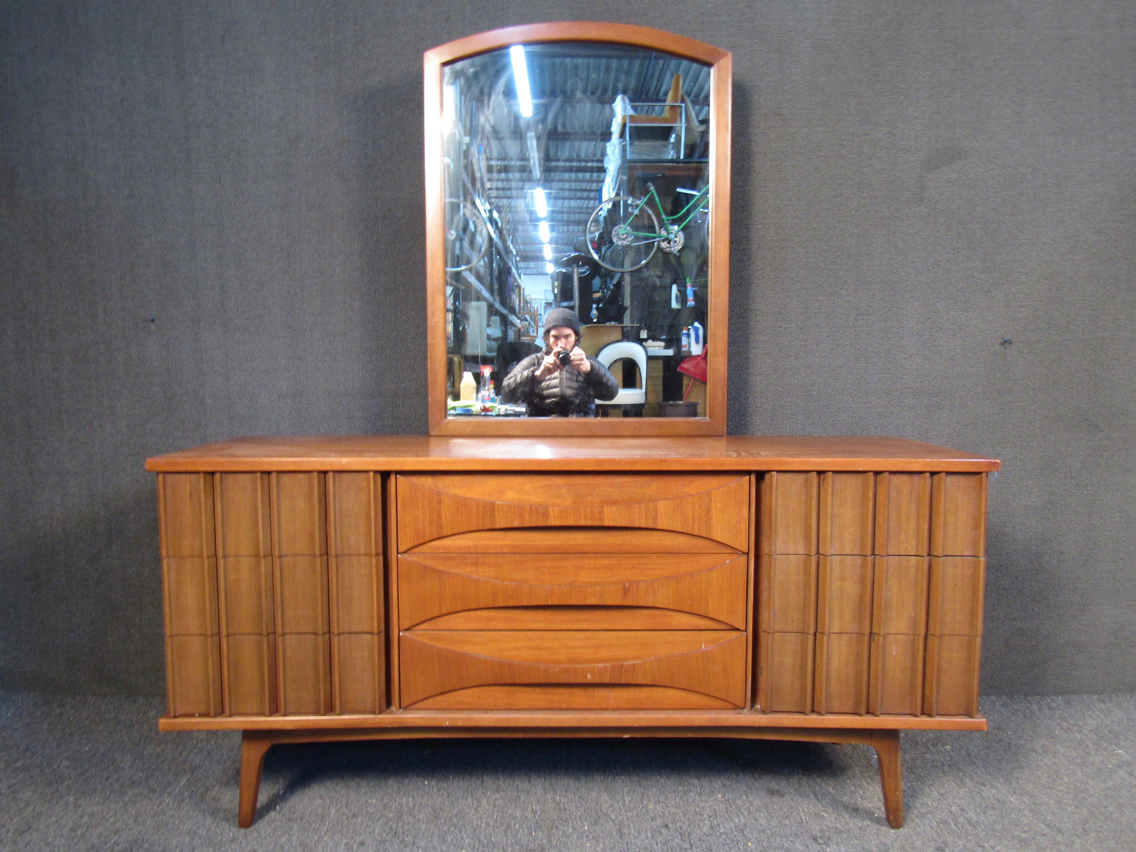 Vintage walnut sideboard featuring nine drawers with unique wood handles and square tapered legs. The mirror included is also full wood and has two metal mounting posts. 
(Please confirm item location - NY or NJ - with dealer).