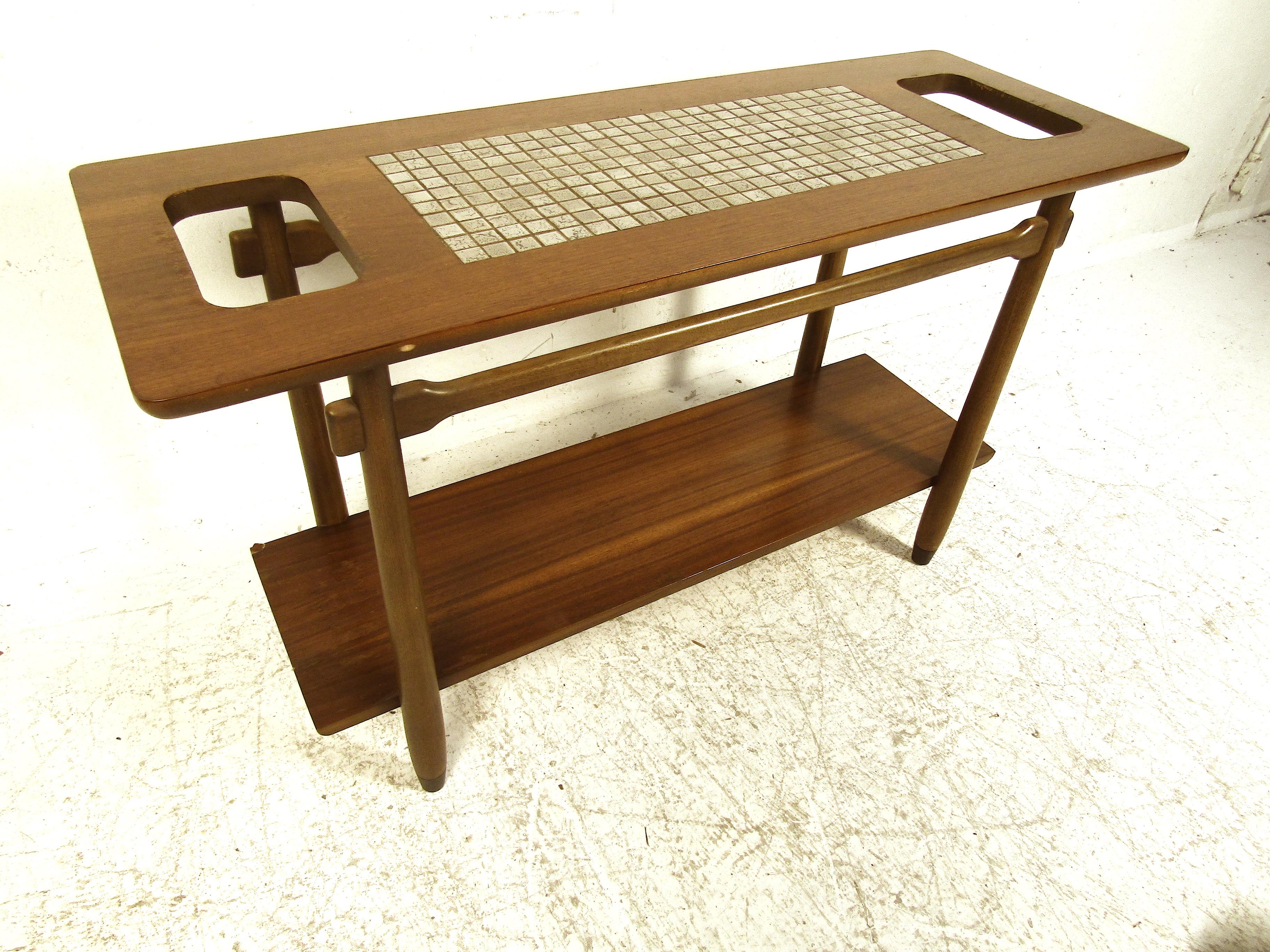 This handsome midcentury sofa table features clean lines with a ceramic tile inlay on top. Perfect for light entertaining or to accent a dining/ living room. Sturdy construction and durable materials ensure this piece will last for years to come.