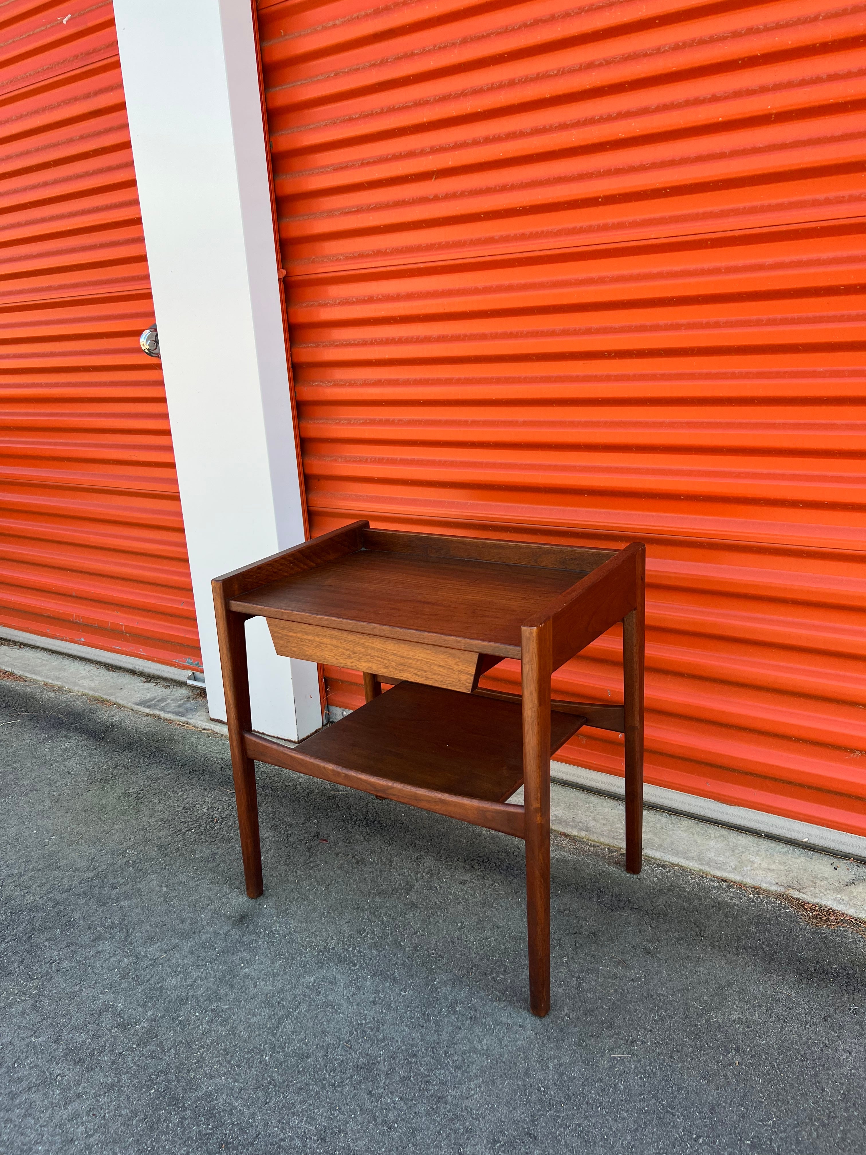 Mid-Century Modern sculptural, hard to find, Jens Risom nightstand or end table with a sleek single drawer and open bottom shelf. Overall good condition with some light scuffing/scratching from age appropriate wear. Labeled on the inside of the