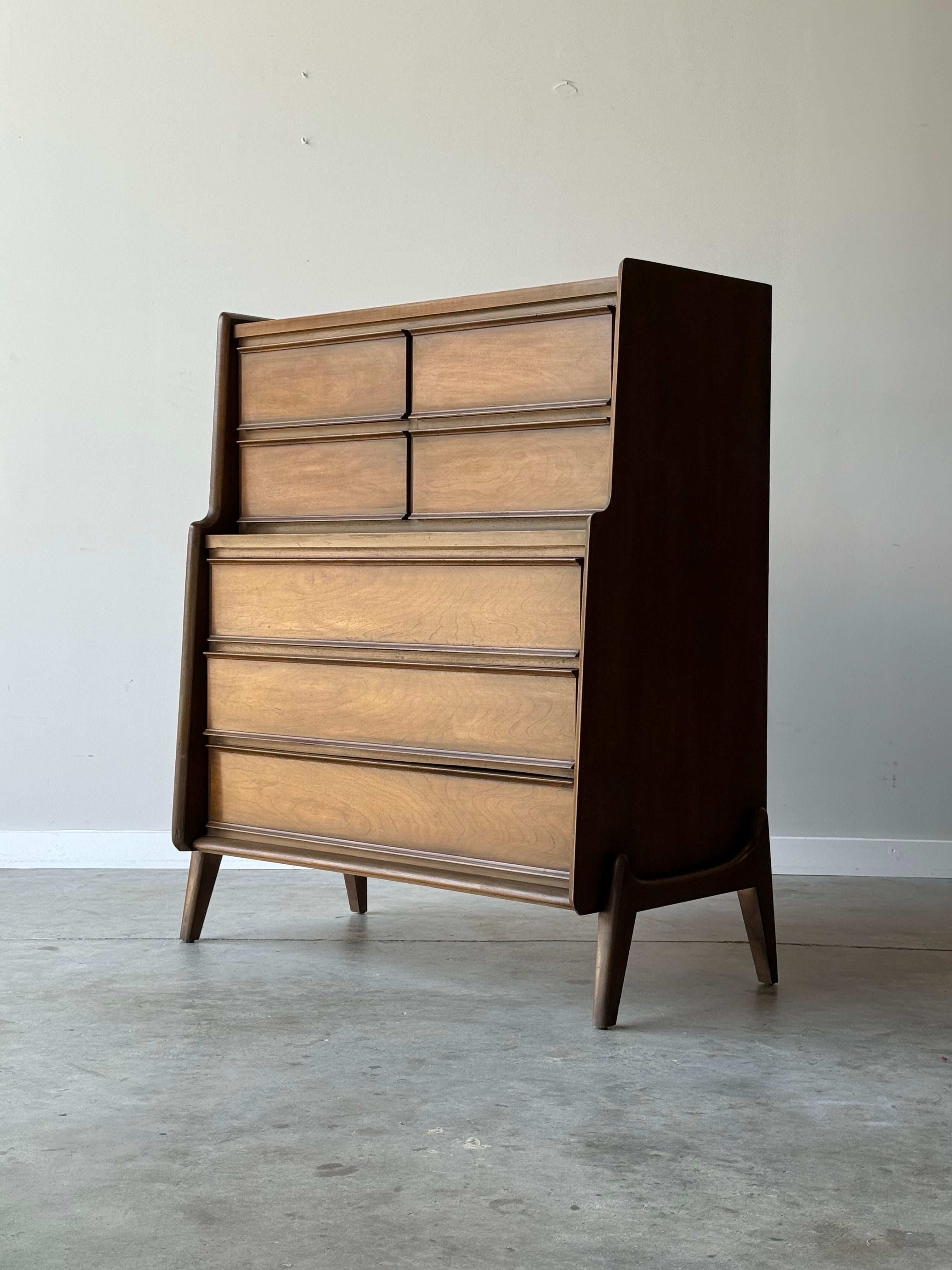 Un ragazzo alto della metà del secolo scorso realizzato in legno di noce. Prodotto da United Furniture Company, circa anni '60. Questa cassettiera alta è dotata di sette cassetti scorrevoli, ottimi per riporre gli oggetti. La parte superiore e i