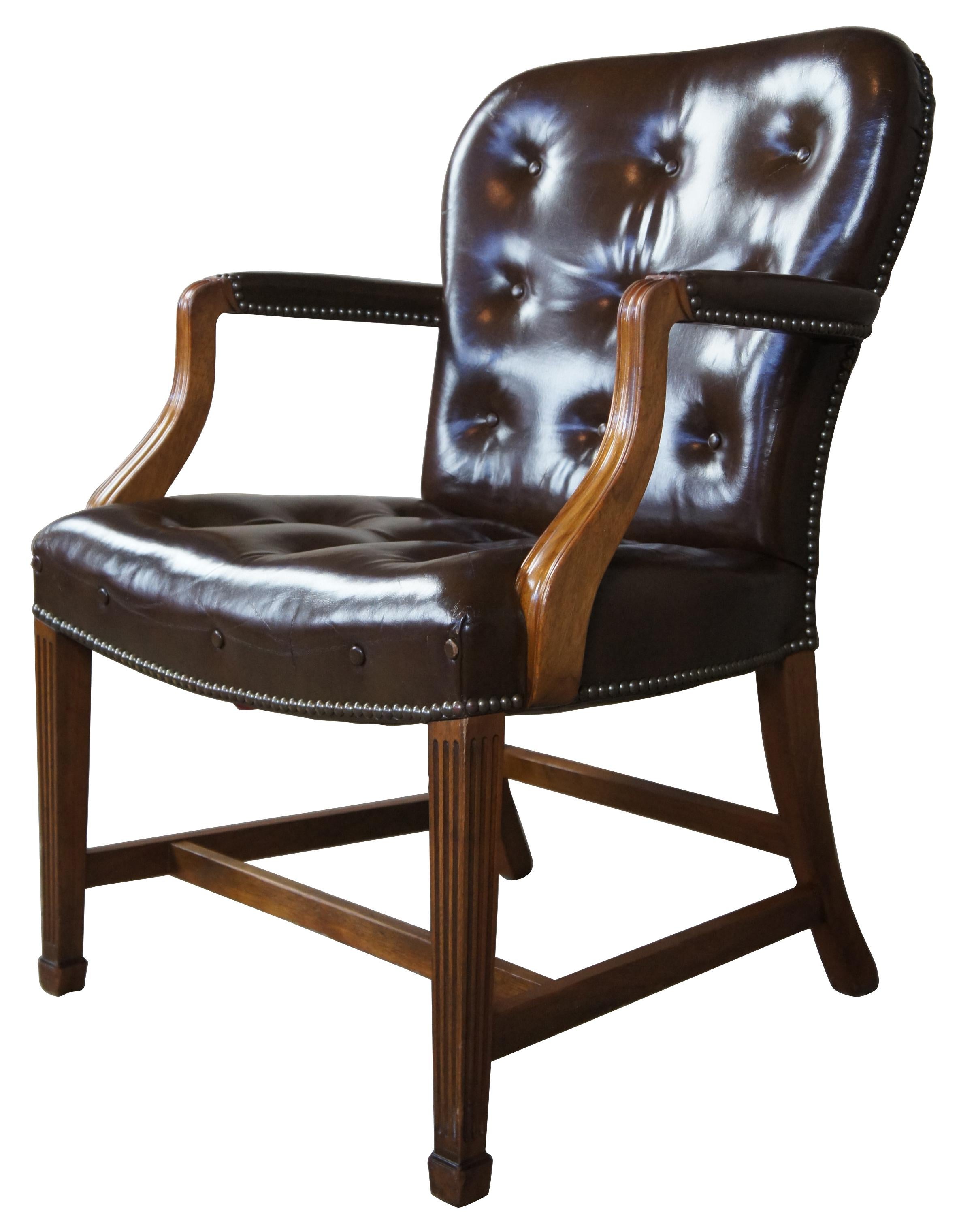 Midcentury walnut and brown leather armchair. Features nailhead accent and tufting with square tapered and fluted legs. 
 