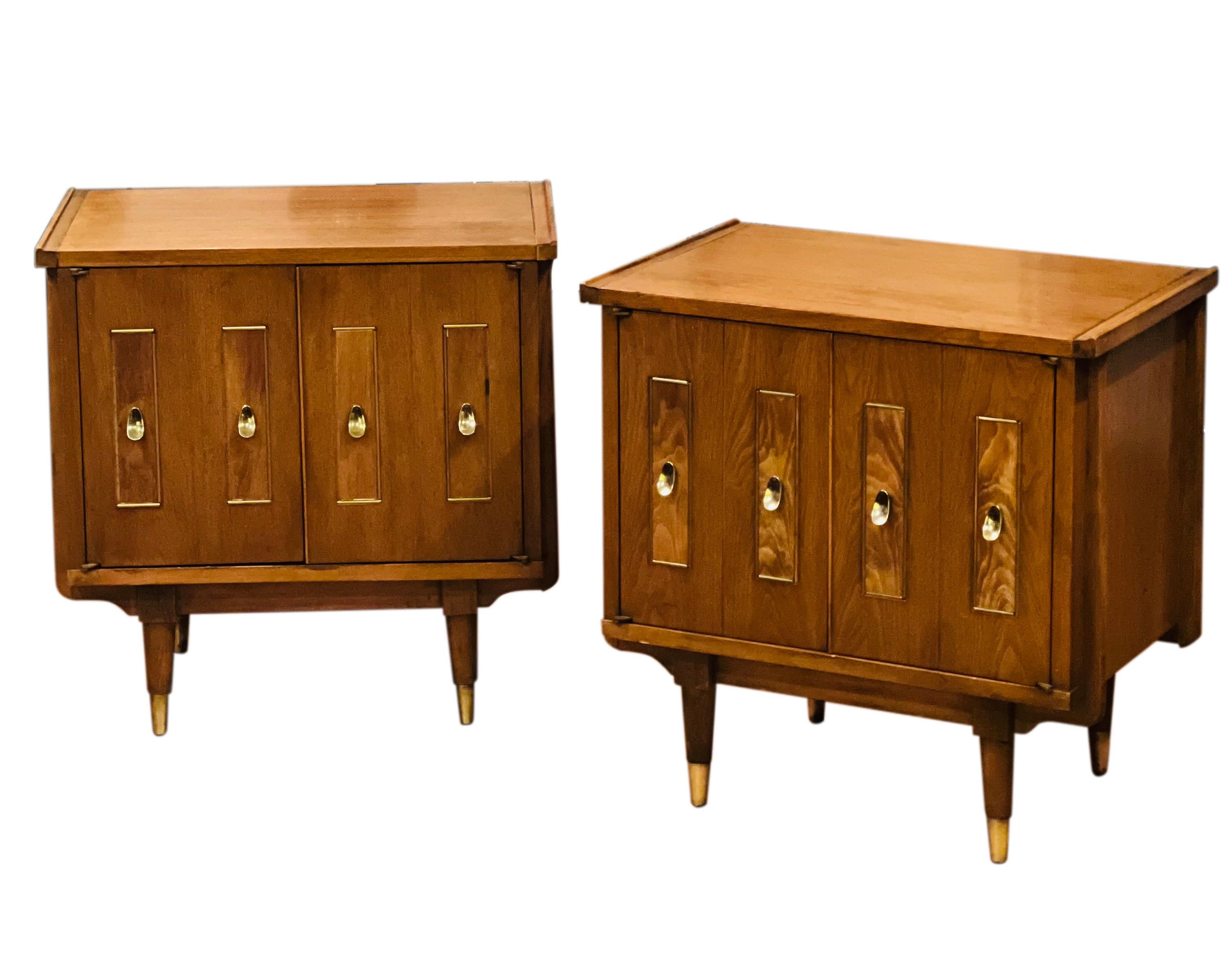 Exceptional pair of mid-century two-door walnut nightstands.

The stands have lots of unique design details throughout. The shiny orecchiette shaped brass pulls beautifully highlight the front paneled doors. They have interesting wood grain with