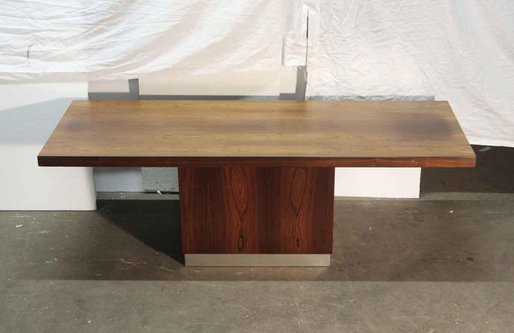 Sleek lines accentuate this Mid-Century Modern walnut veneer coffee table with rectangular base. The wooden base includes a nickel band at the bottom giving it a unique streamlined look.