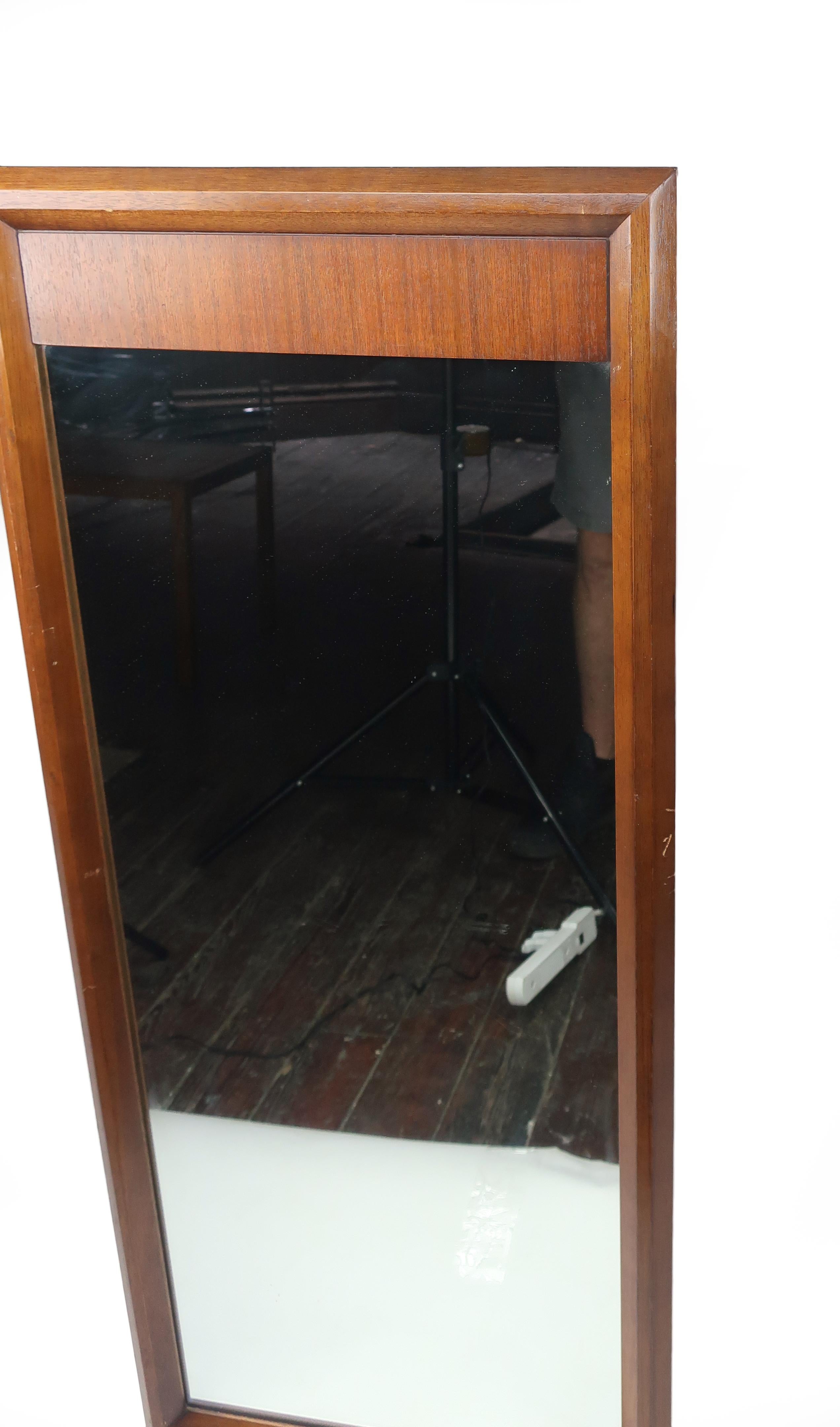 A handsome Mid-Century Modern walnut wall mirror. Rectangular with a strip of richly grained wood across the top it would be great in an entry way, hallway or bedroom. In good vintage condition with wear consistent with age and use. Marked “Galax