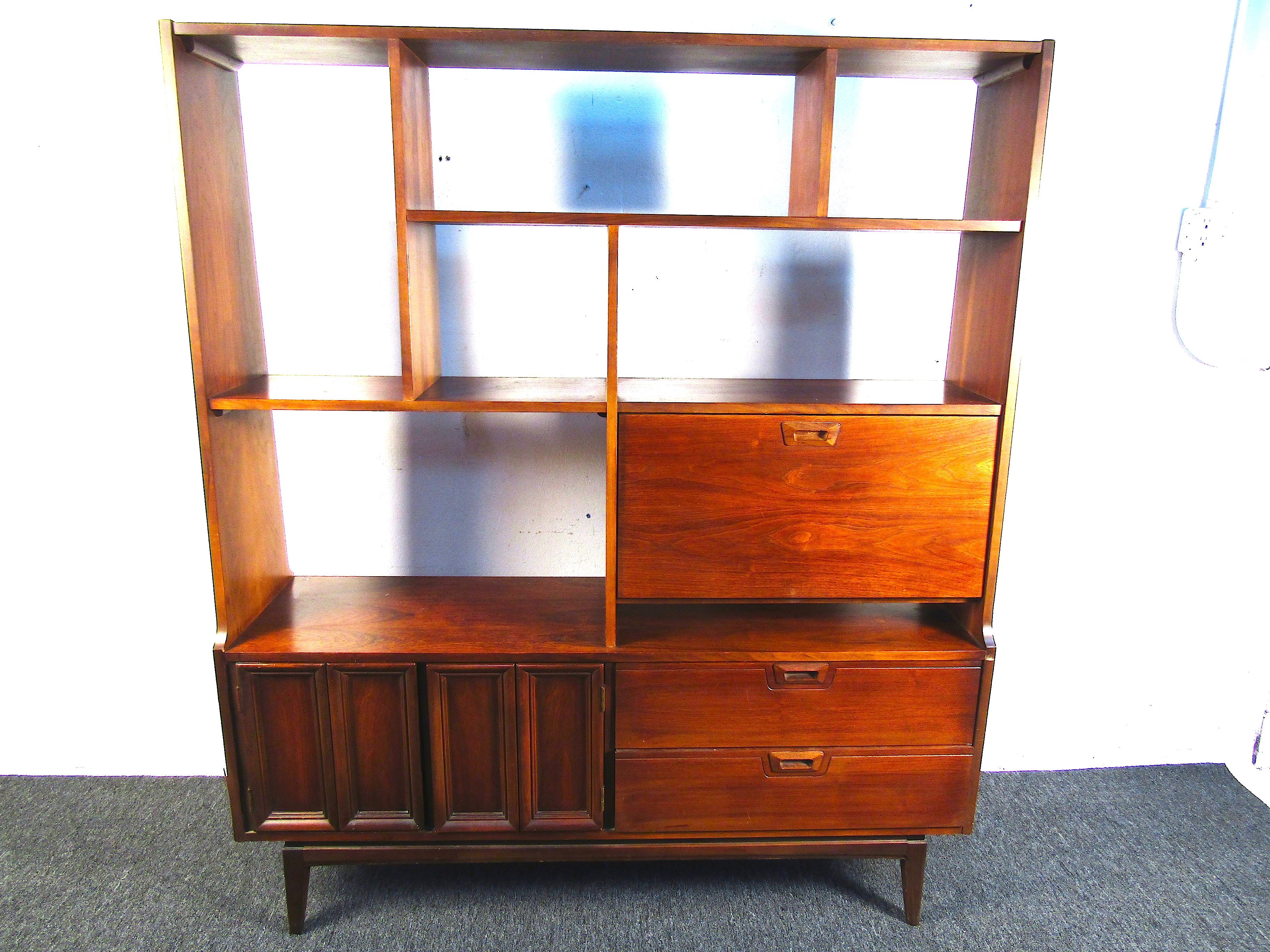 This beautiful midcentury wall unit is perfect for storing all those old books, records, or anything you can imagine. With the impressive overall size and ample storage, this piece is both functional and beautiful. Please confirm the item's location