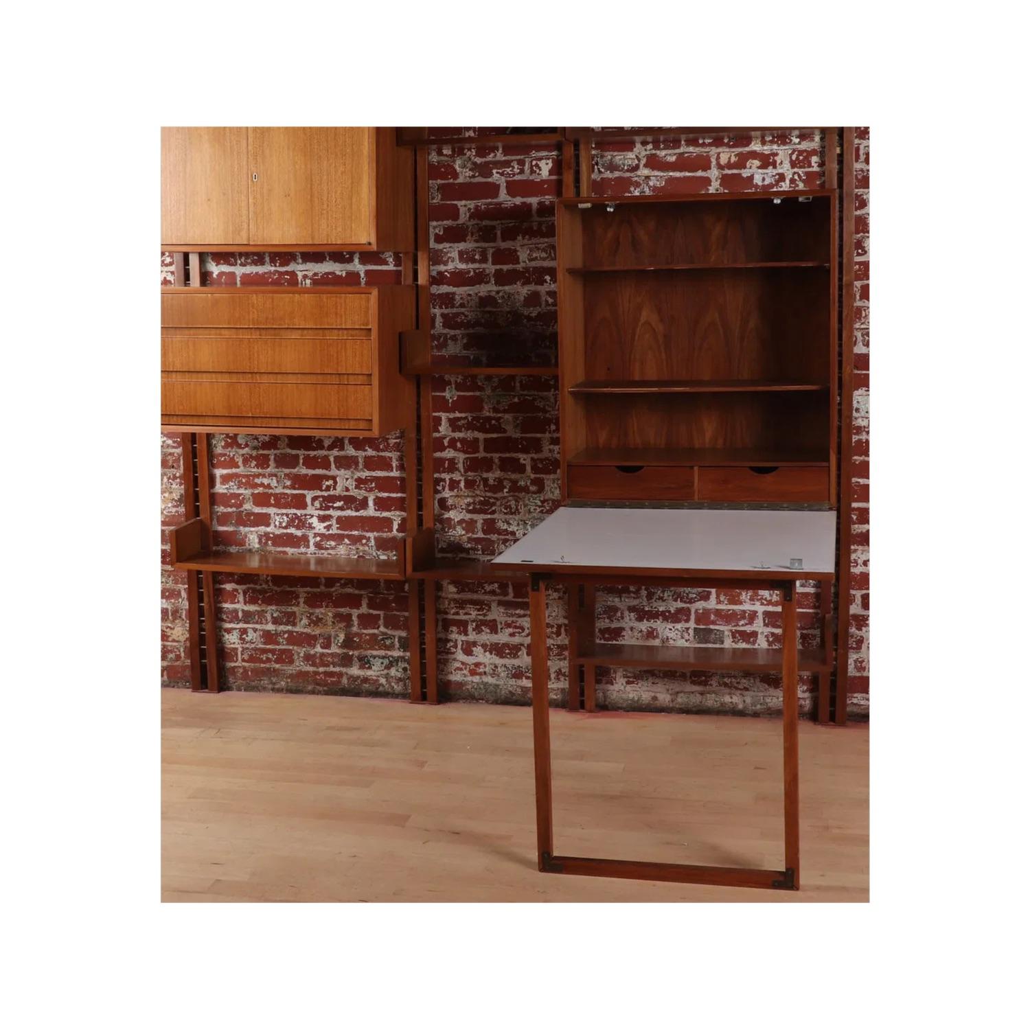 A classic mid-century wall unit with four wall mounted upright rails where four short and two long adjustable shelves sit on the patinated metal rungs. Additionally, this unit includes one 3-drawer cabinet and one 2-door cabinet which are also