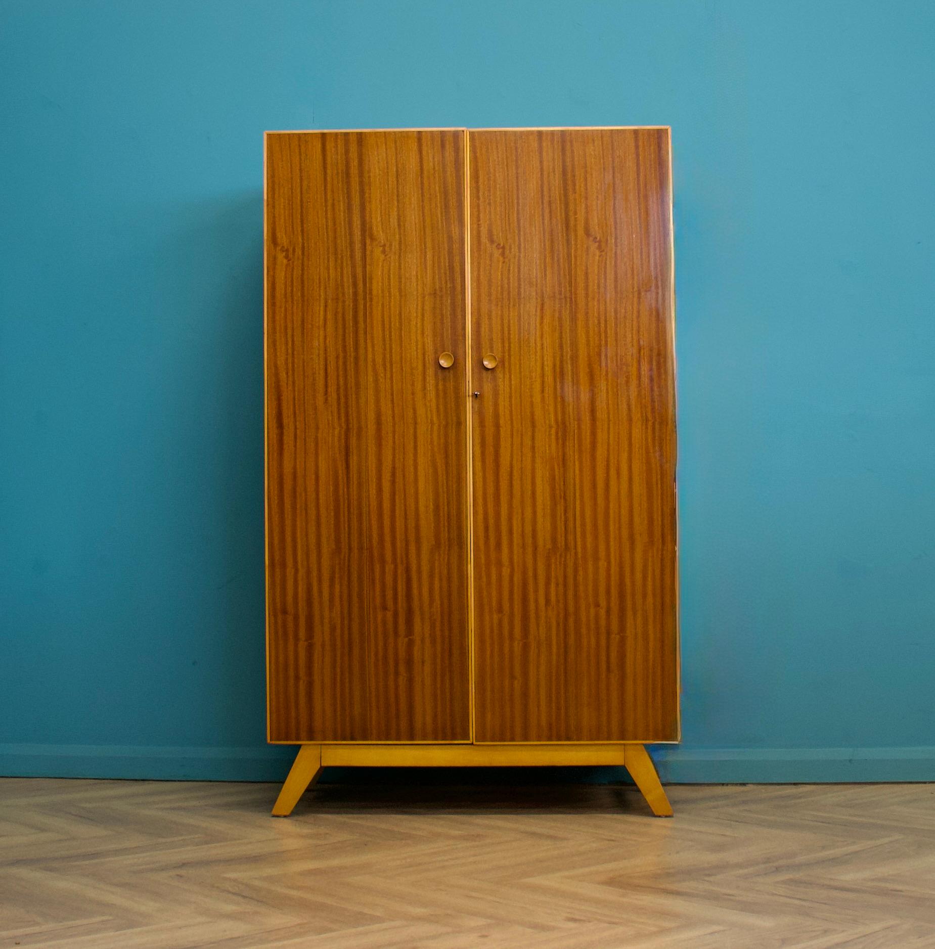 Armadio in noce della metà del secolo scorso, anni '60 circa.

Presenta una finitura lucida sulle ante e gambe distanziate.

L'armadio comprende due appendiabiti e una mensola.

Questo pezzo può essere diviso in due parti