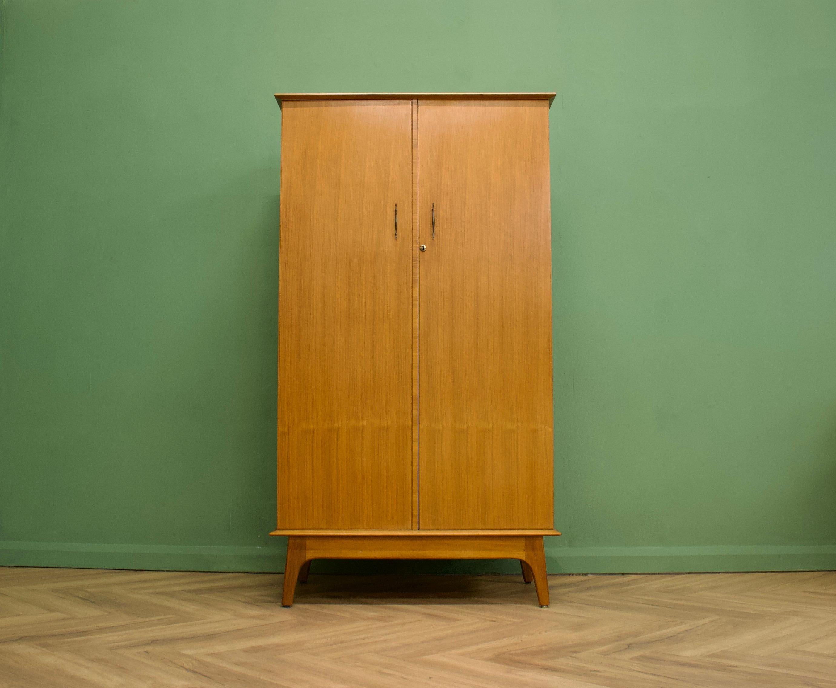 A walnut freestanding wardrobe by Alfred Cox - these pieces were almost always retailed through Heals department store during the 1950s and 1960s
Internally there are two hanging rails, shelves and a drawer
The attractive legs are splayed and the