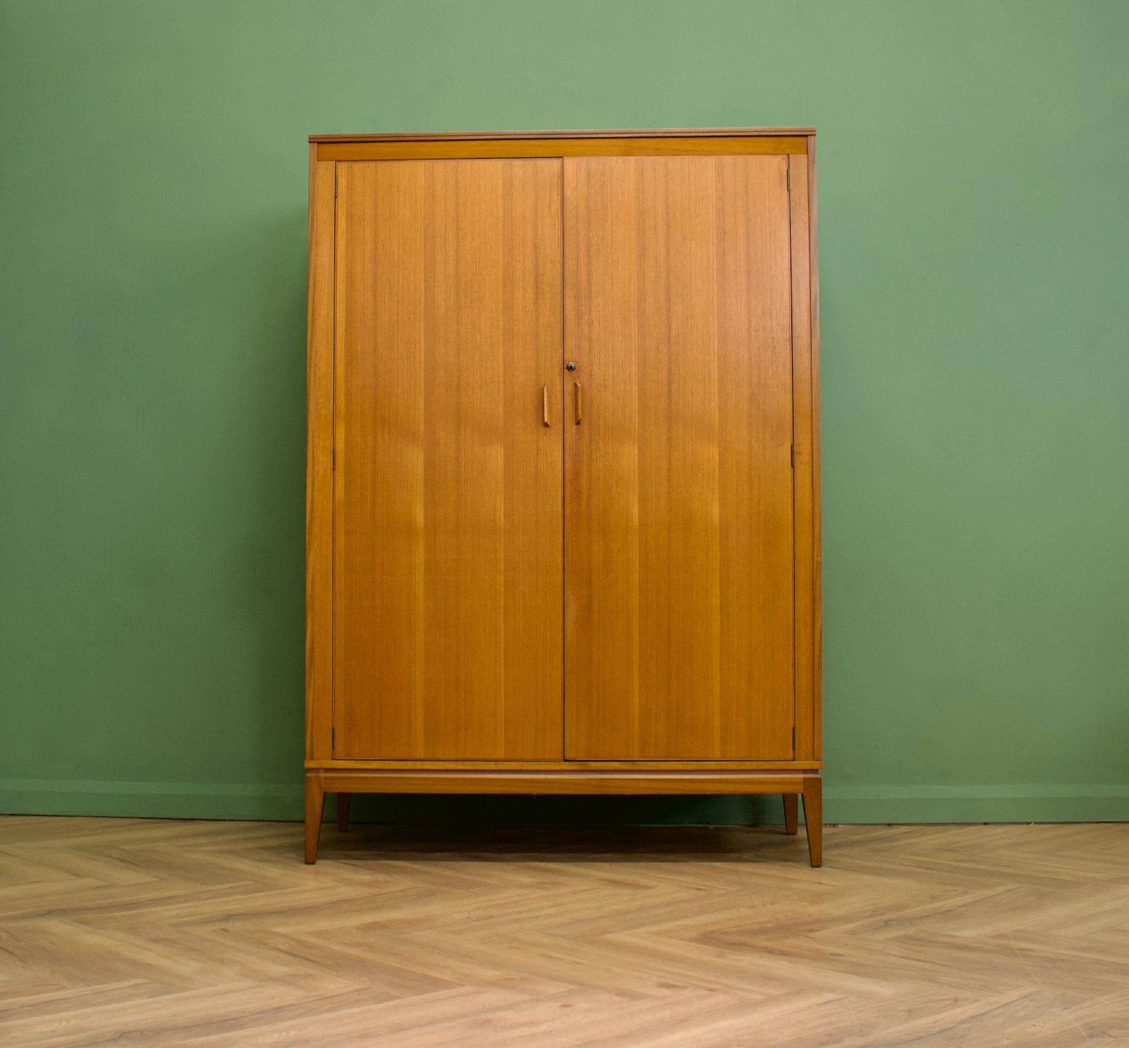 A walnut freestanding wardrobe by Alfred Cox - these pieces were usually retailed through Heals department store during the 1950s and 1960s
Internally there are two hanging rails and a shelf
The attractive legs are slightly tapered and splayed and