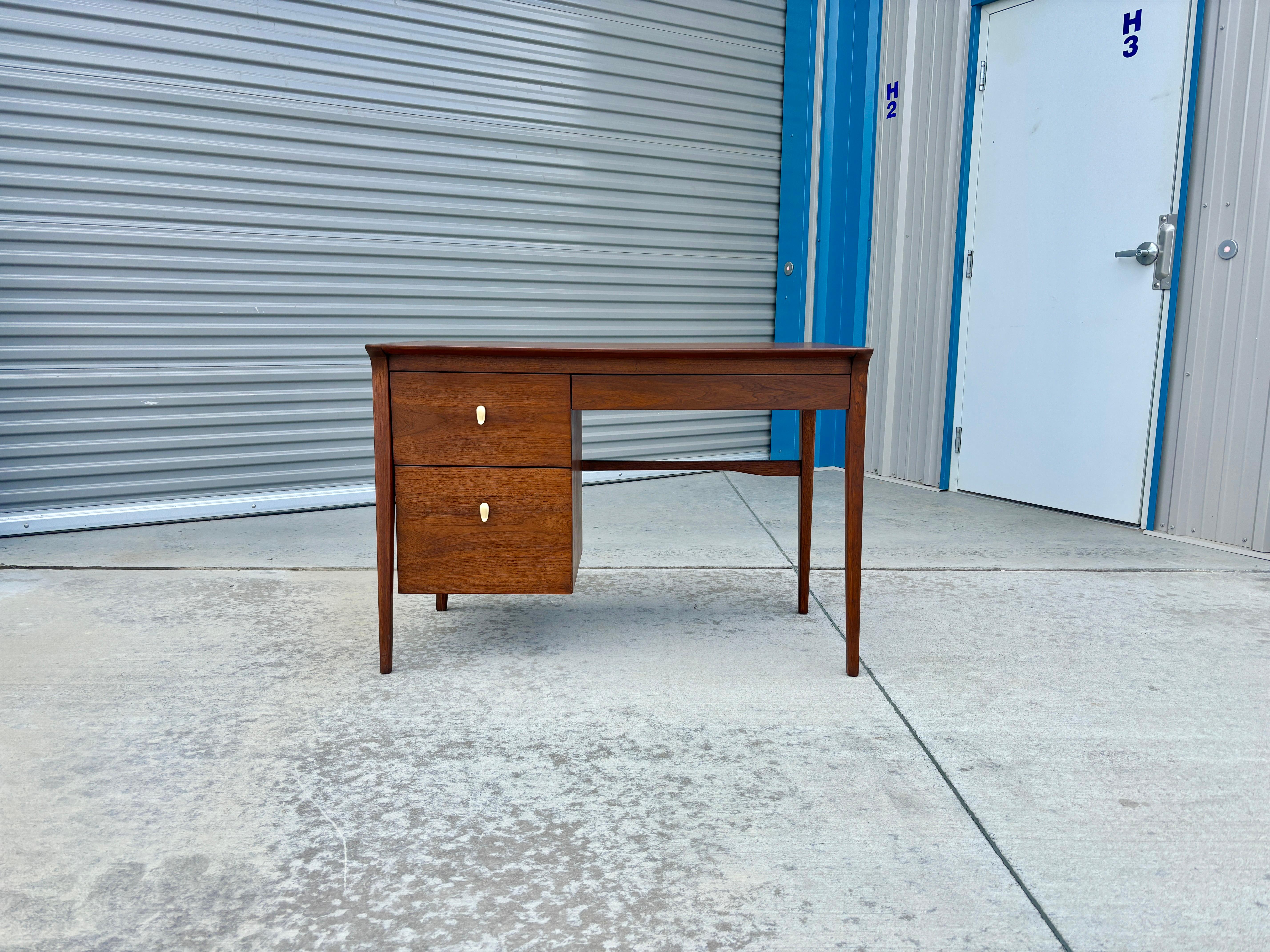 Mid century walnut writing desk designed by John Van Koert and manufactured by Drexel in the United States circa 1960s. Made from high-quality walnut, this desk radiates elegance and sophistication, making it the perfect addition to any office or