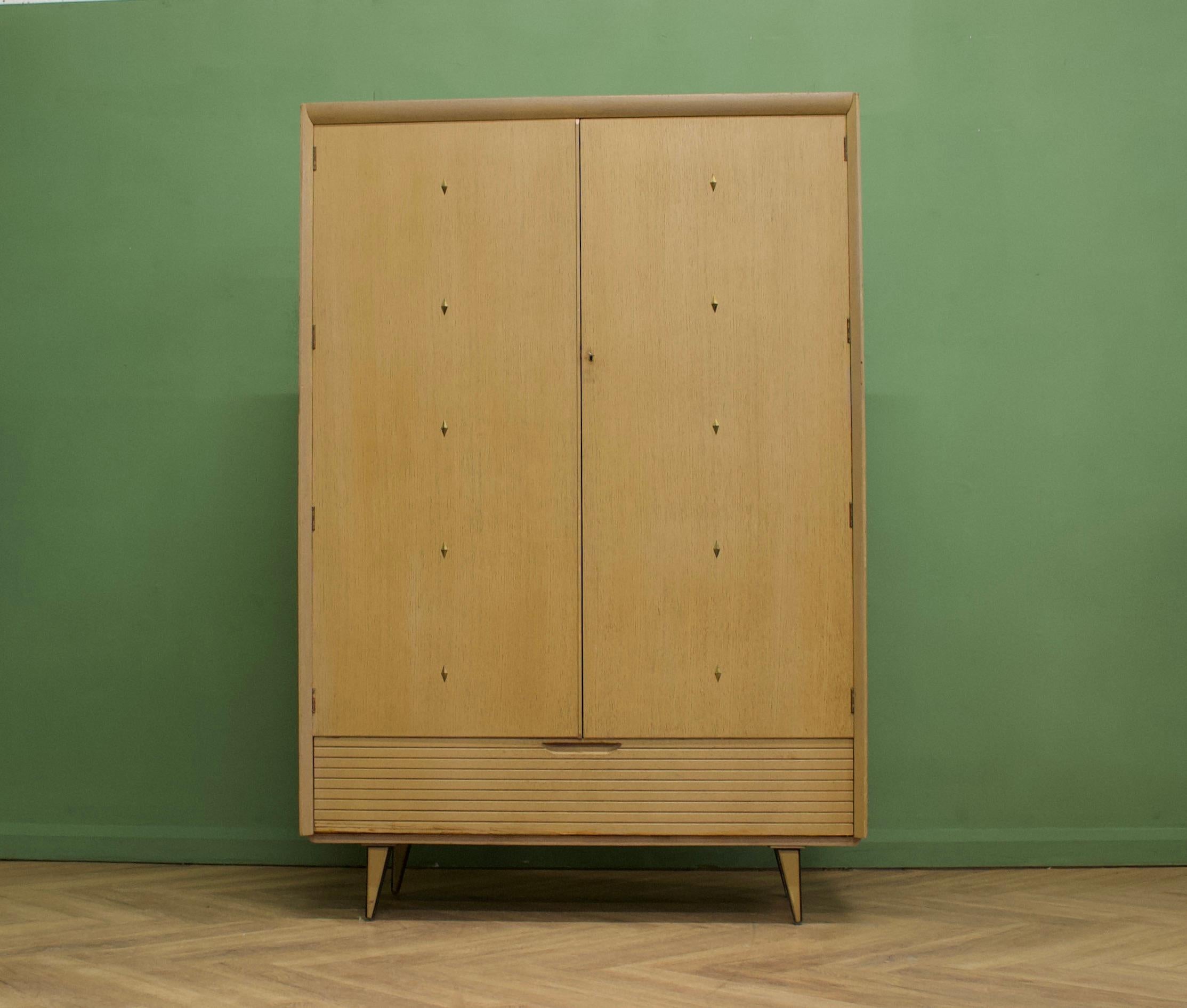 - Mid century modern wardrobe
- Manufactured by Lebus from the Atomic Range
- Limed oak effect & teak
- Features a rail the full width and a pull down cupboard to the bottom