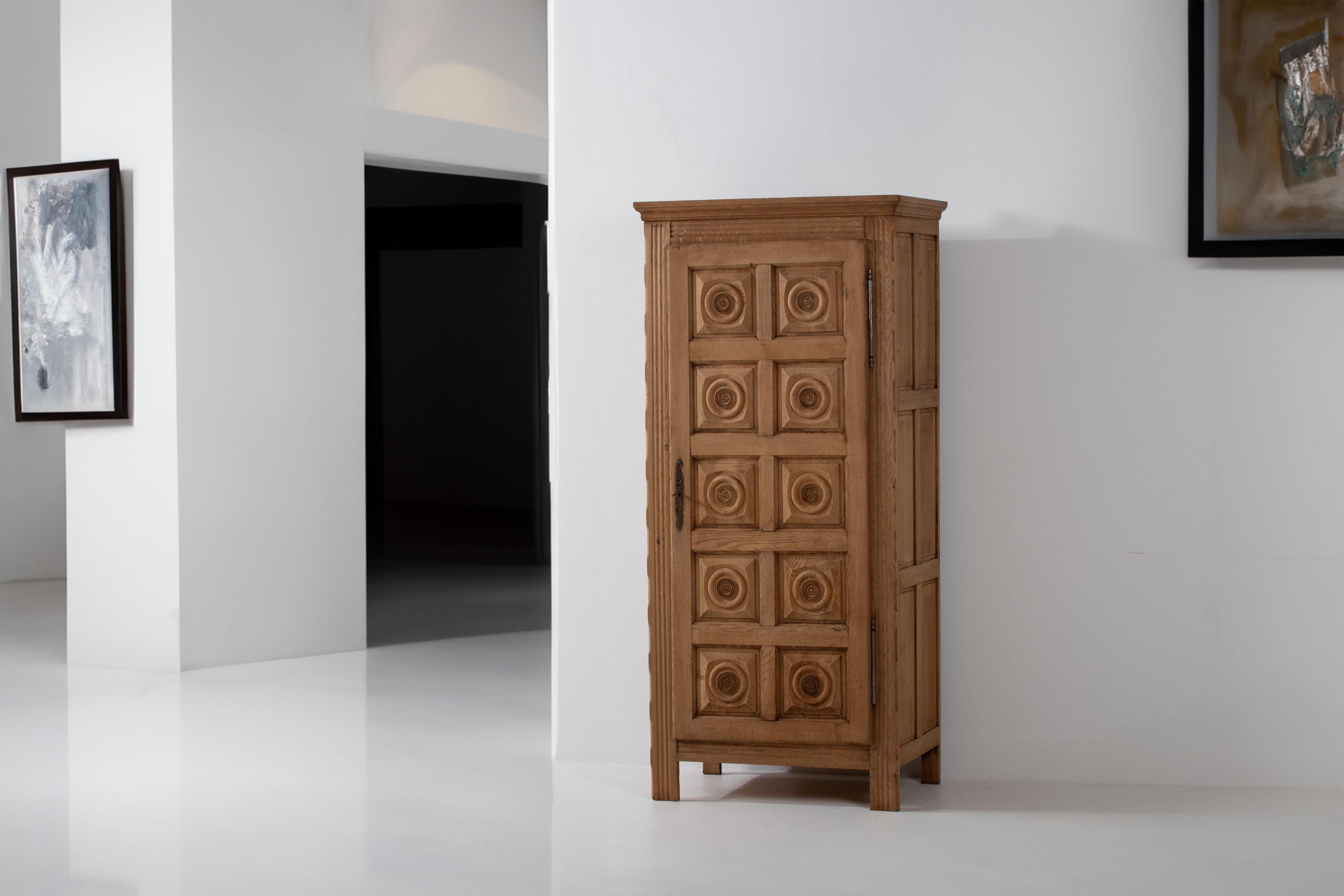 Nous vous présentons une magnifique armoire en chêne, qui rend hommage au style emblématique de Charles Dudouyt, figure emblématique du mobilier français. Cette pièce date des années 1950 et incarne le charme durable de l'artisanat français du