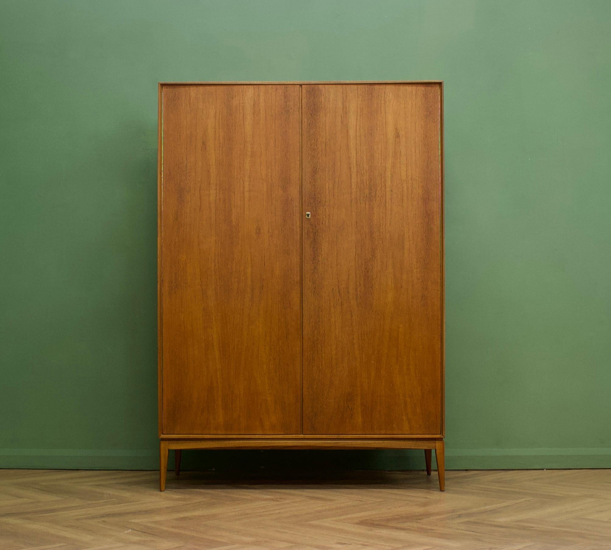 A freestanding double door teak wardrobe from McIntosh - in the Danish modern style Made during the 1960s Fitted out with two clothes rail and fixed shelving for ample storage
The style of this wardrobe is minimalist - with it's clean lines,
