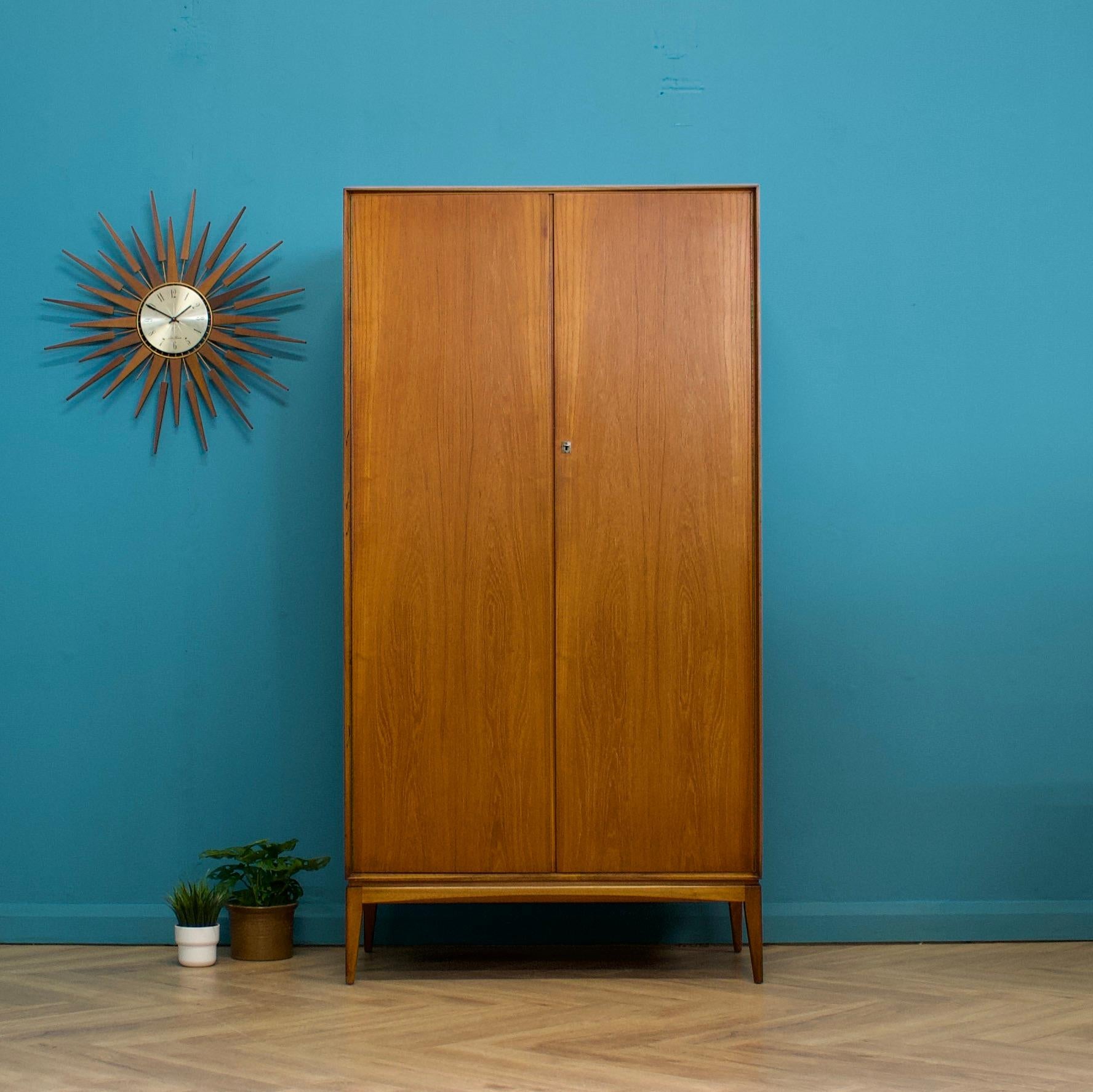 A freestanding double door teak wardrobe from McIntosh - in the Danish modern style Made during the 1960s Fitted out with a clothes rail and fixed shelving for ample storage.
The style of this wardrobe is minimalist - with it's clean lines, handless