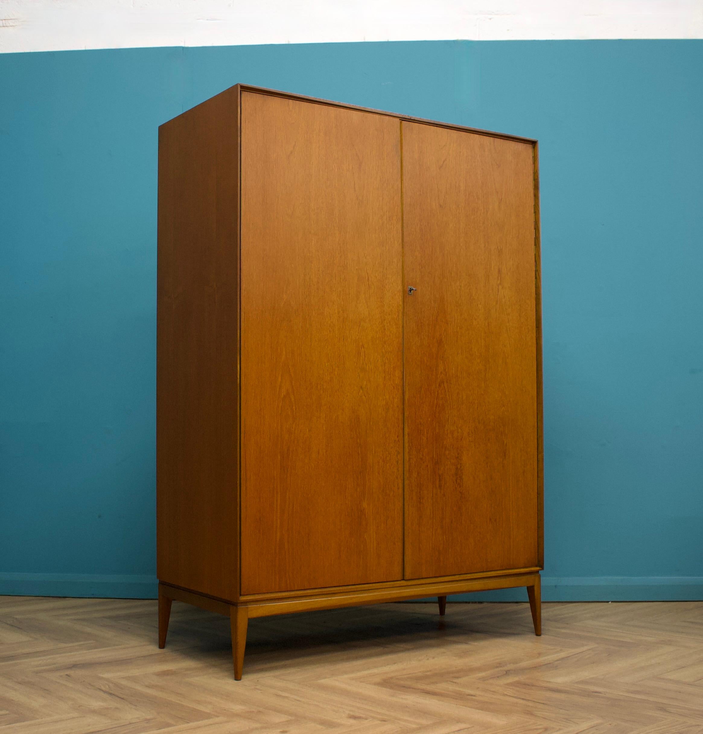 Un armadio indipendente a due ante in teak di McIntosh - in stile moderno danese Realizzato negli anni '60 Dotato di due appendiabiti e scaffali fissi per un ampio spazio di archiviazione
Lo stile di questo armadio è minimalista, con le sue linee