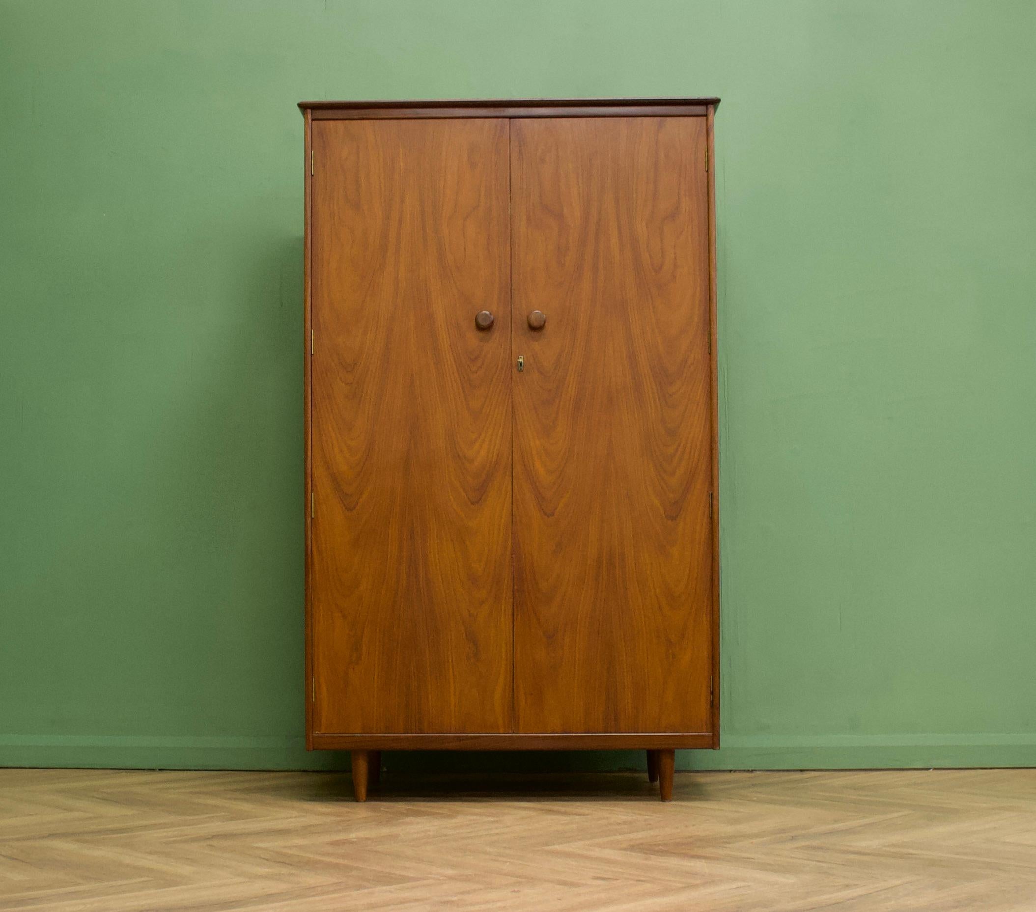A walnut freestanding wardrobe by Butilux - circa 1960s
Internally there is a hanging rail, shelves , drawers and compartments - a lot of storage for such a compact wardrobe
The attractive legs are slightly tapered and the handles are solid wood -